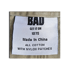 JAKE & IPI Bad Get It On workwear pants label showing olive green cotton fabric and nylon patch details