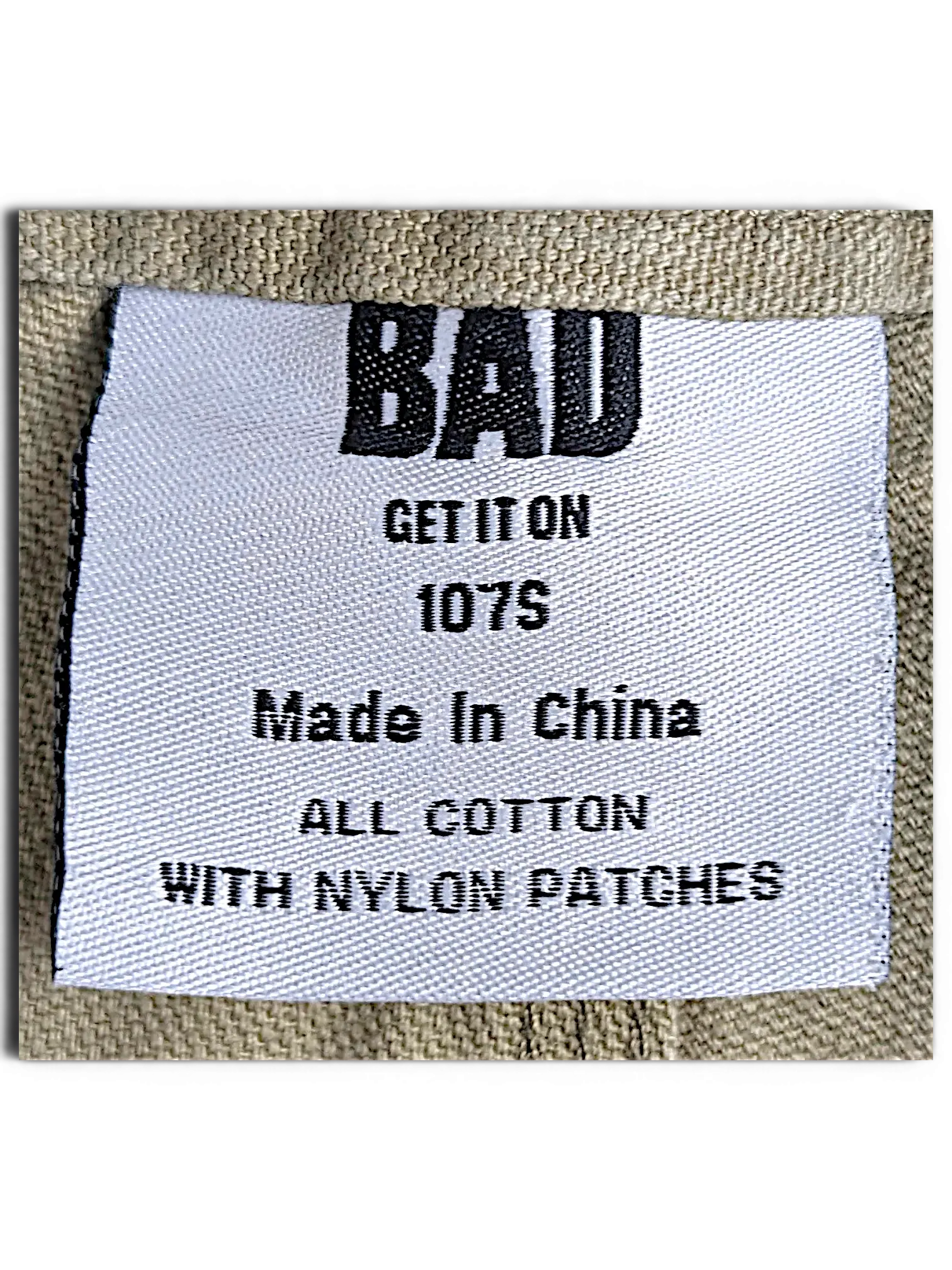 JAKE & IPI Bad Get It On workwear pants label showing olive green cotton fabric and nylon patch details