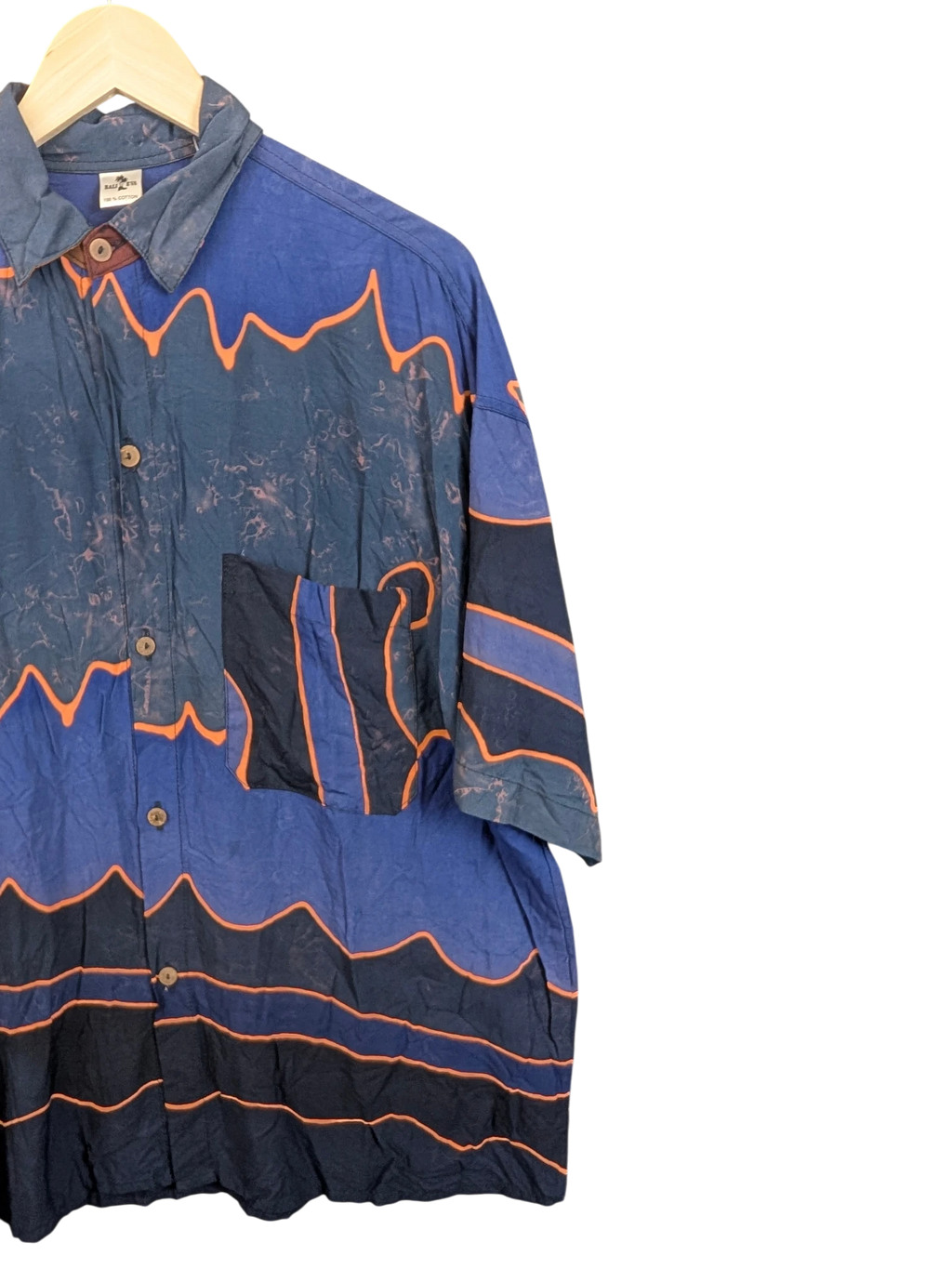 JAKE & IPI Bali Eva Hawaiian shirt in blue with orange wave patterns, button-down front, and chest pocket.