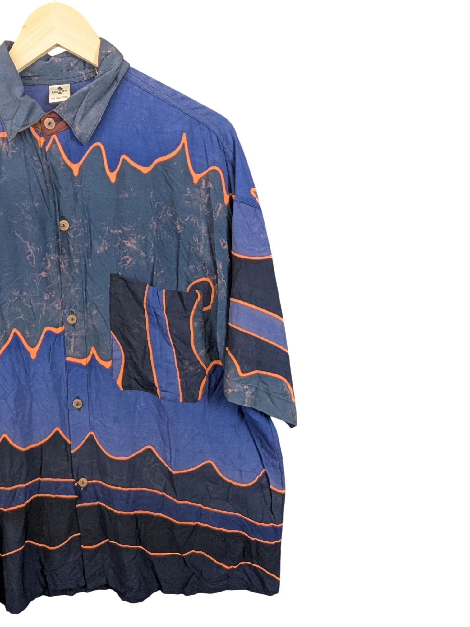 JAKE & IPI Bali Eva Hawaiian shirt in blue with orange wave patterns, button-down front, and chest pocket.