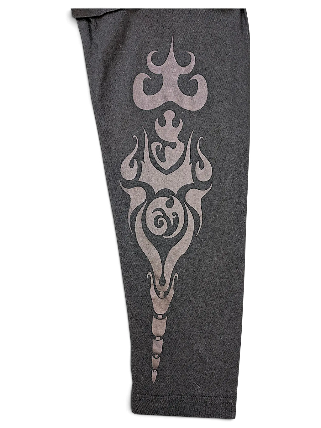 Close-up of a black JAKE & IPI IBE Mori Velle long-sleeve shirt sleeve featuring a grey tribal-style graphic print.
