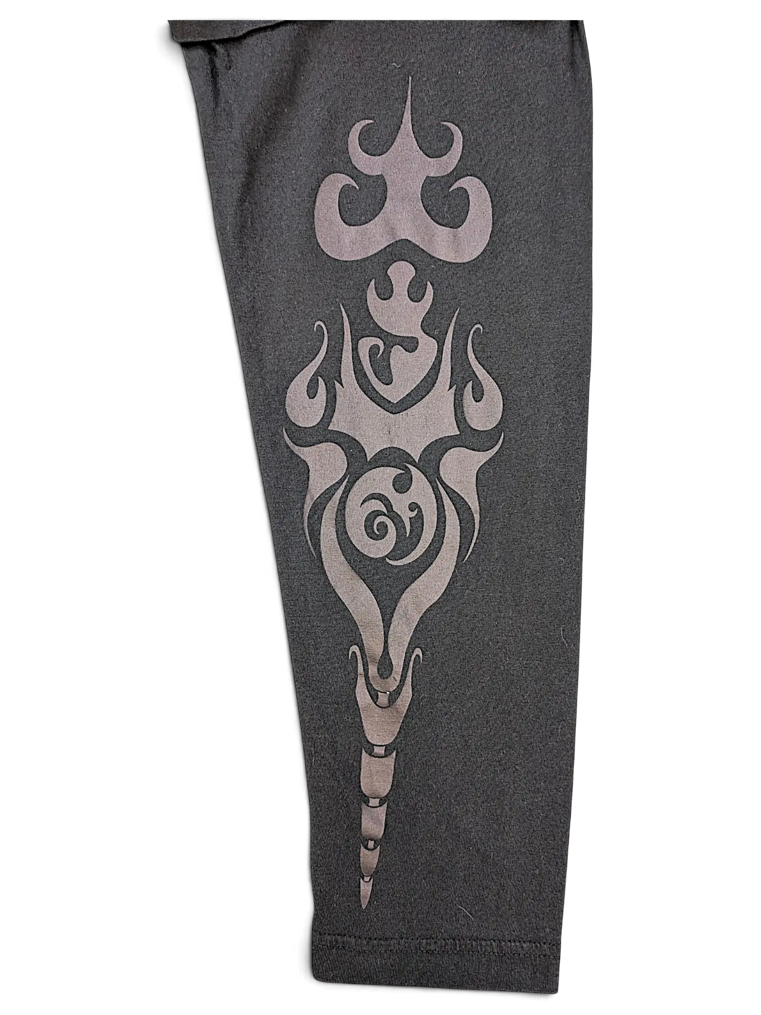 Close-up of a black JAKE & IPI IBE Mori Velle long-sleeve shirt sleeve featuring a grey tribal-style graphic print.