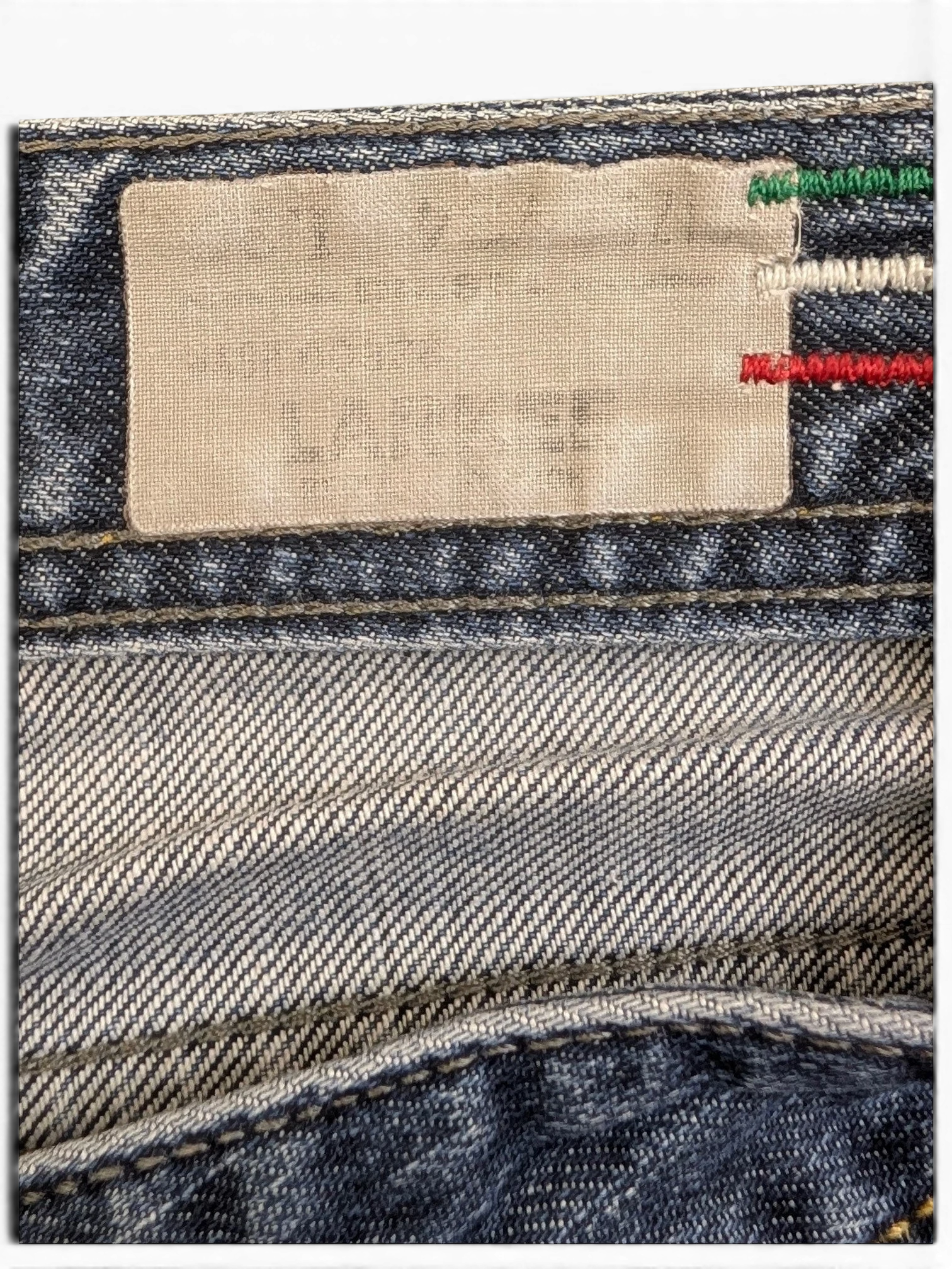 JAKE & IPI blue denim jeans with a size label and Italian flag stitching detail.