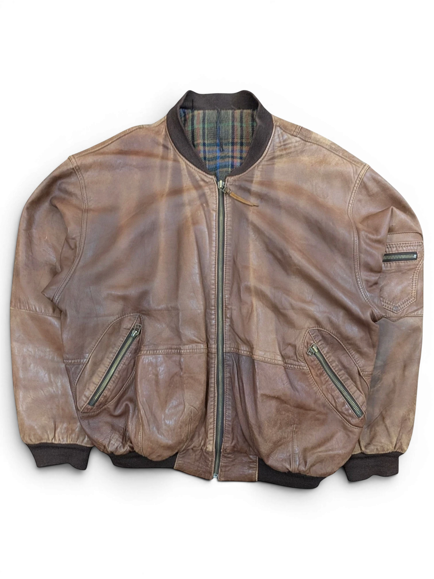 JAKE & IPI brown distressed leather bomber jacket with plaid lining and zippered pockets.