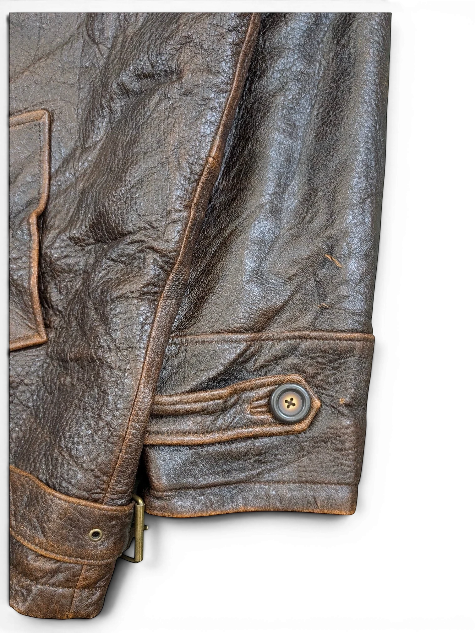 JAKE & IPI brown distressed leather jacket with button detail on cuff and adjustable buckle at hem.