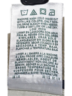 JAKE & IPI care label for vintage beige pleated trousers with washing instructions in English, Spanish, and French.