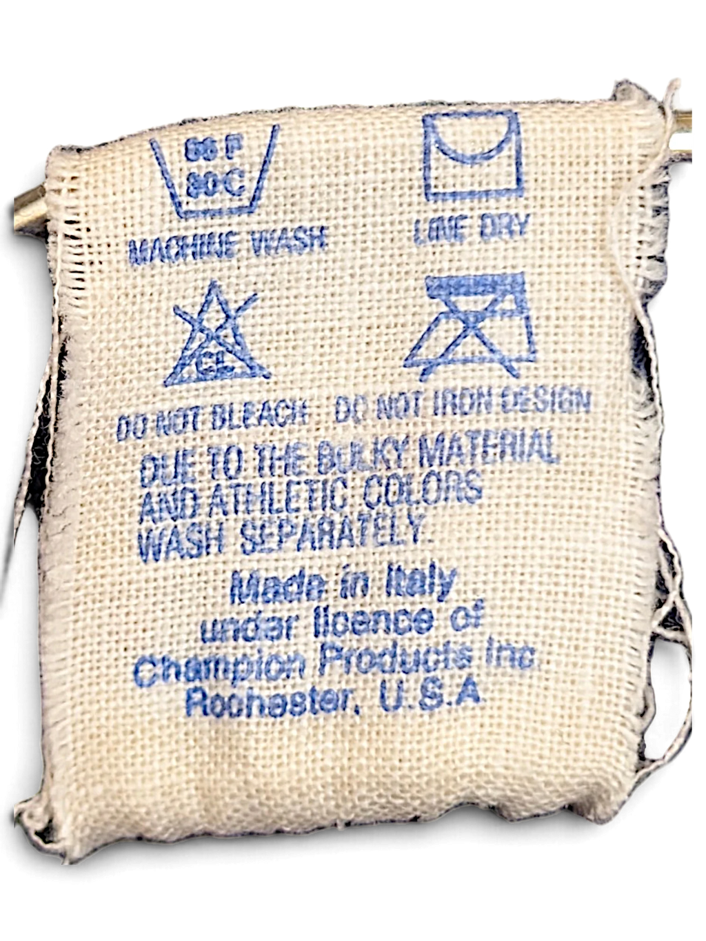 JAKE & IPI Champion track pants care label with washing instructions and origin details on a woven fabric tag