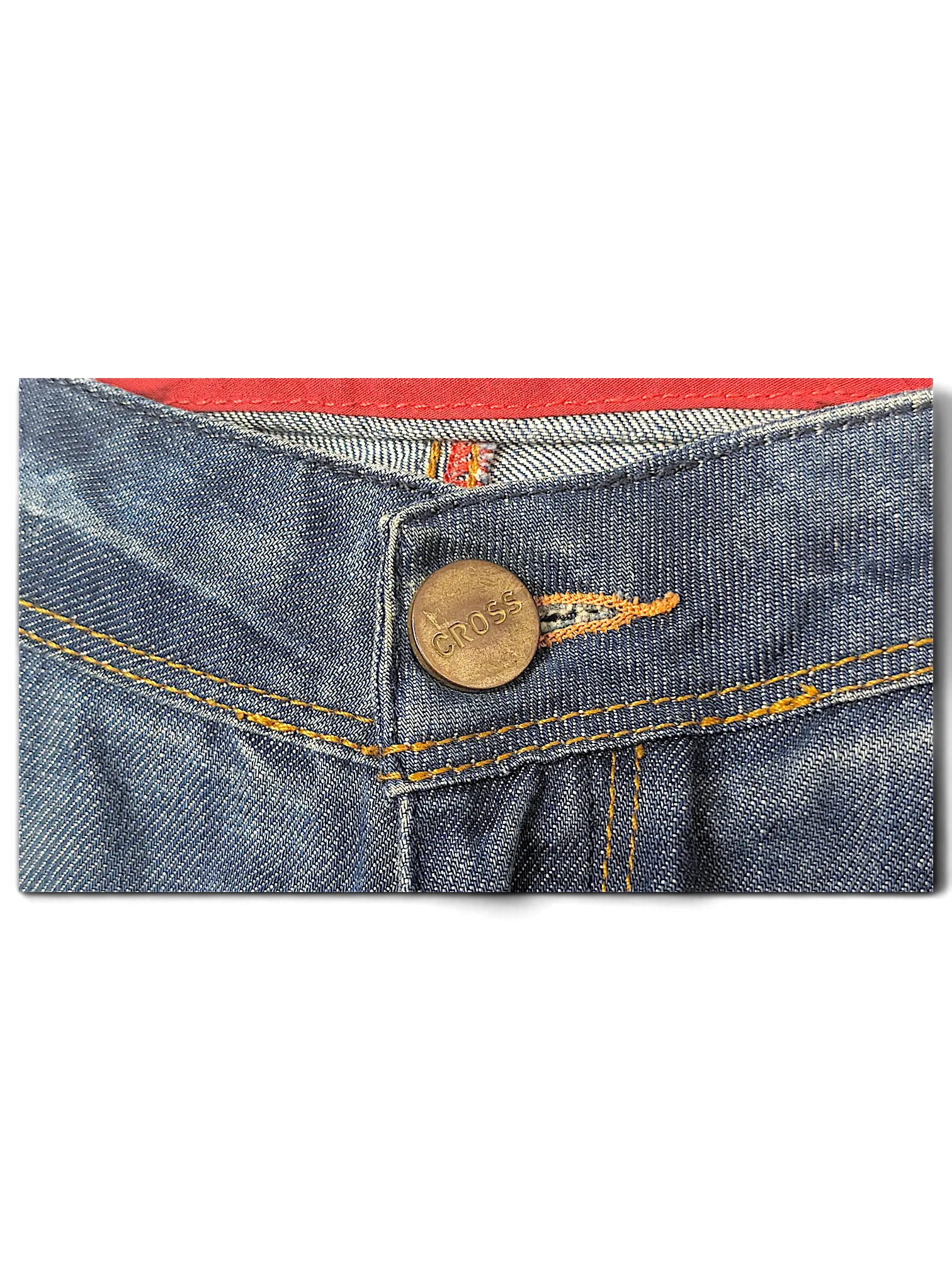 JAKE & IPI blue denim jeans featuring a brass button embossed with the Cross logo and contrast orange stitching.