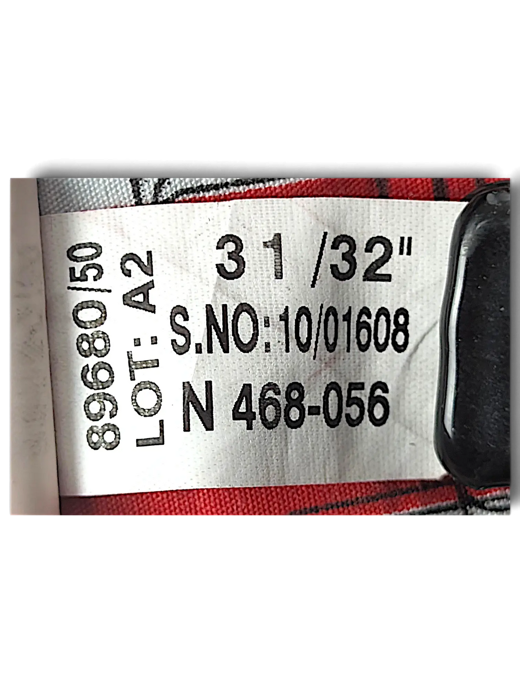 JAKE & IPI Cross Jeanswear co clothing label showing size W31 L32 and care instructions on red and white patterned fabric