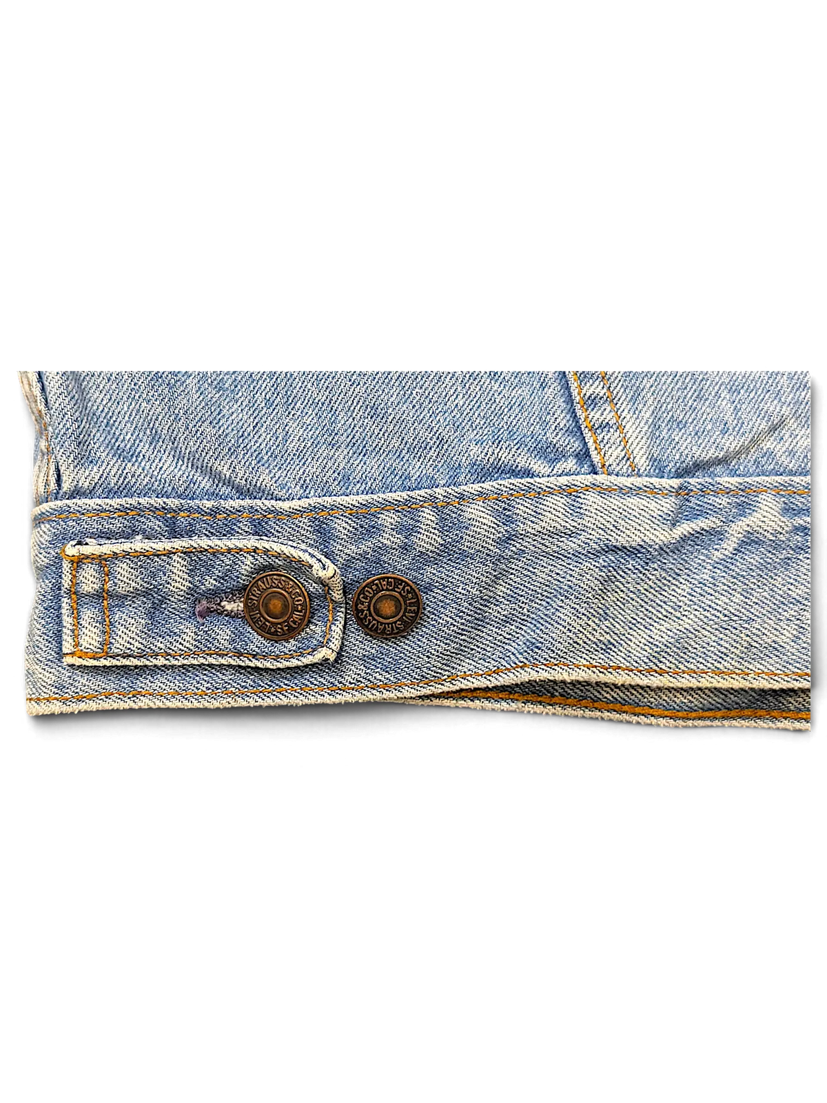 JAKE & IPI vintage light wash denim jacket hem detail with branded metal buttons and adjustable side tab
