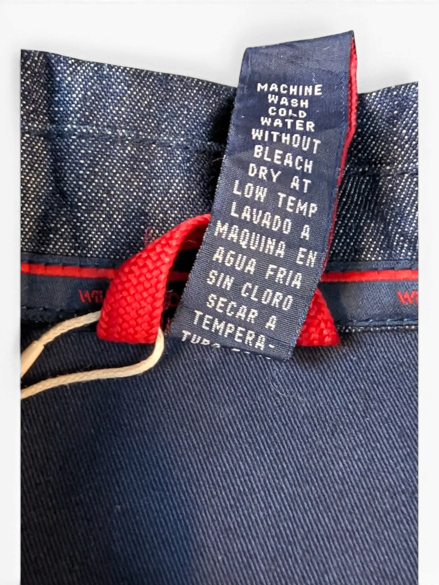 JAKE & IPI Willie Esco denim jacket care label showing machine wash cold, no bleach, dry on low temp.