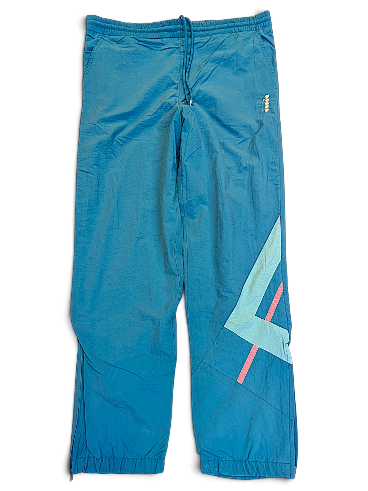 JAKE & IPI pre-owned Diadora faded light blue track pants with relaxed fit, embroidered logo, and geometric accents.
