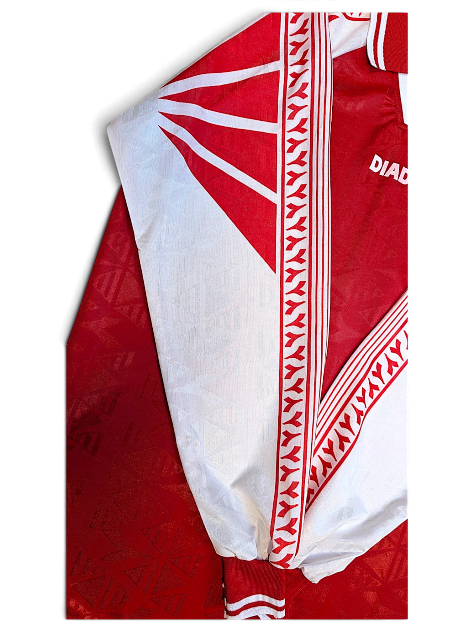 JAKE & IPI Diadora Grit red football jersey showing contrast white sleeve panels and logo taping