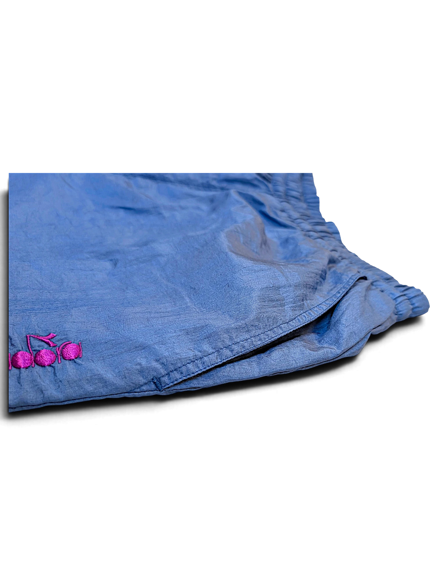 JAKE & IPI pre-owned light blue Diadora track pants with a shiny finish and pink embroidered logo detail.