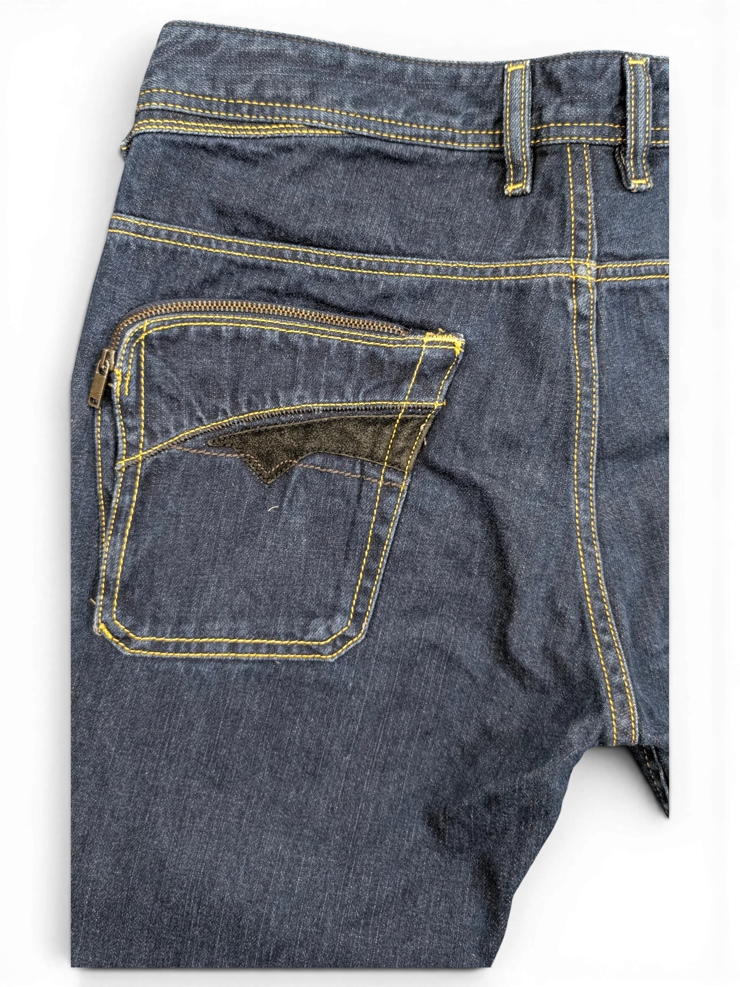 JAKE & IPI dark wash denim jeans with yellow stitching and a unique zippered back pocket featuring black velvet trim.