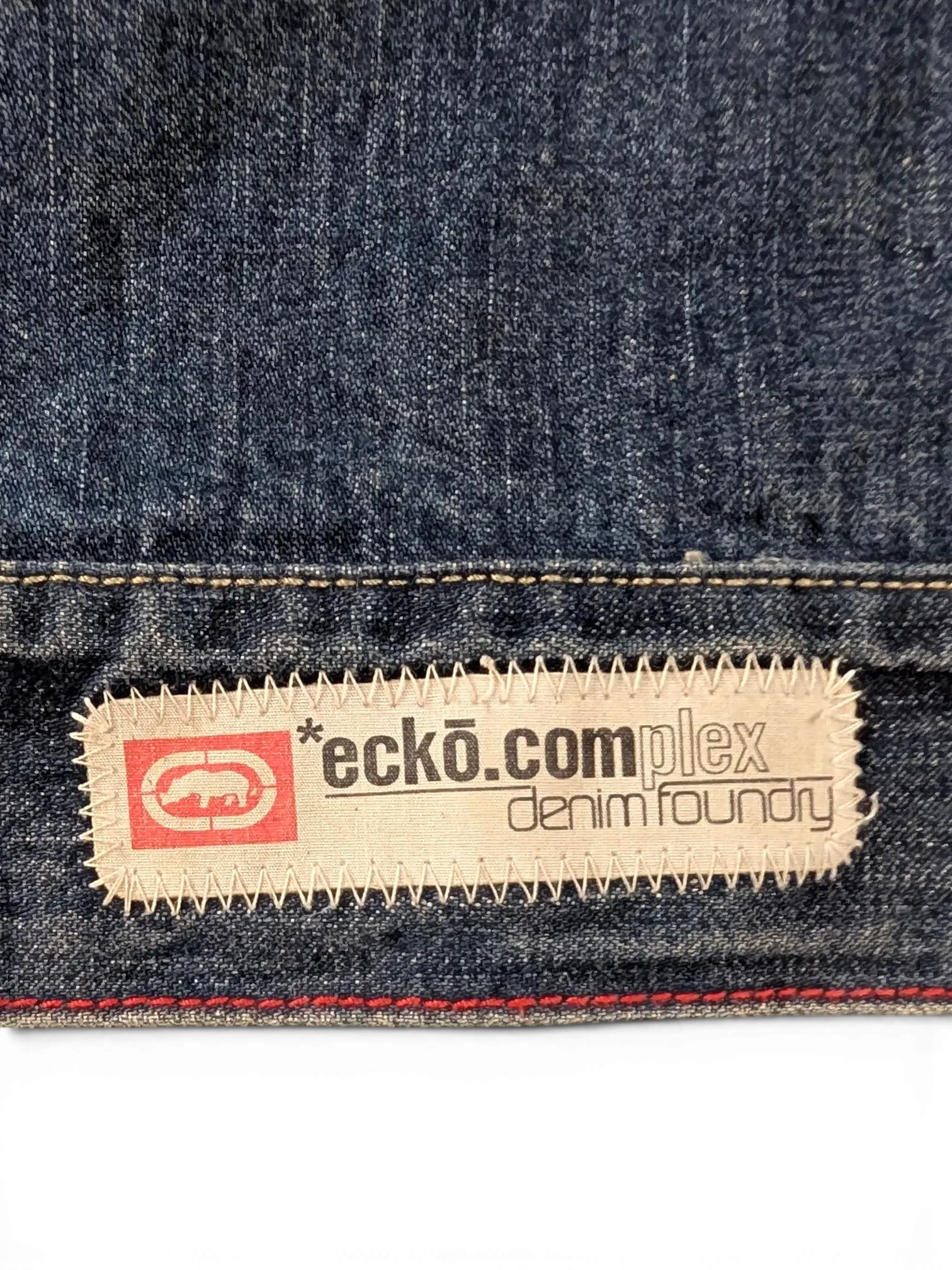 JAKE & IPI Ecko denim jacket with embroidered logo patch and red stitching detail.