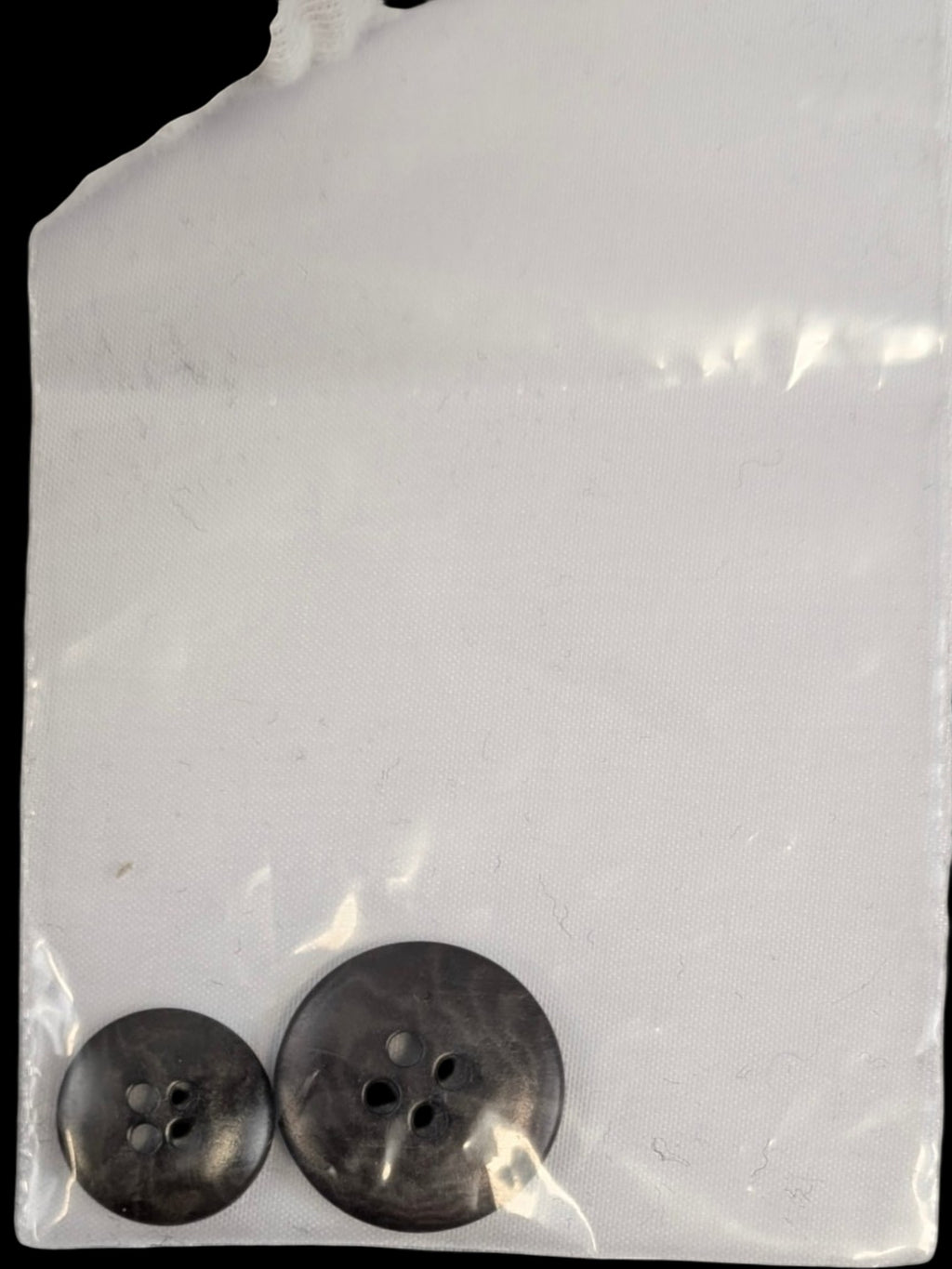 JAKE & IPI two dark grey marbled buttons, one large and one small, with four holes each.