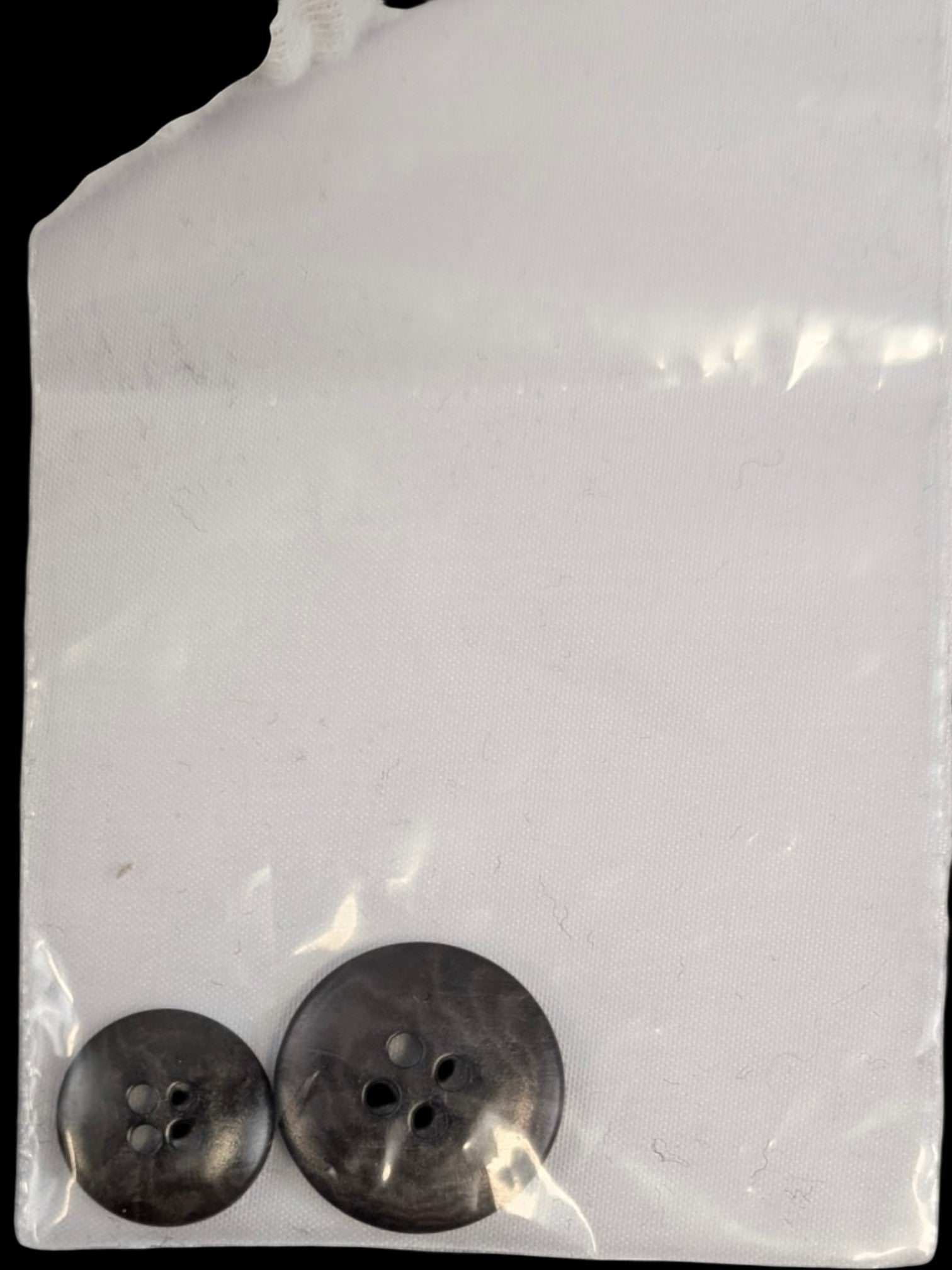 JAKE & IPI two dark grey marbled buttons, one large and one small, with four holes each.