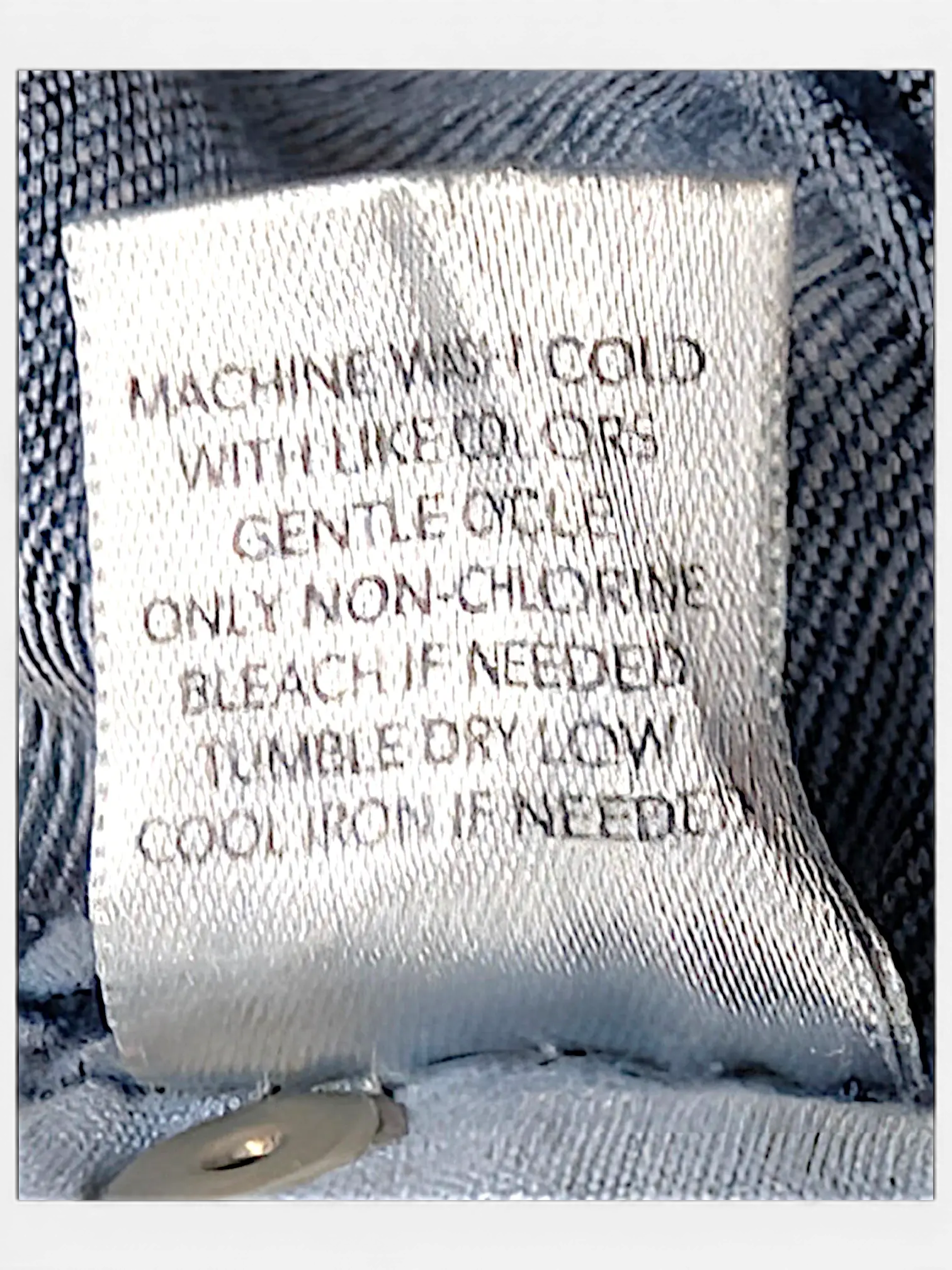 JAKE & IPI CJ Banks jeans care label with washing instructions stitched onto blue denim fabric