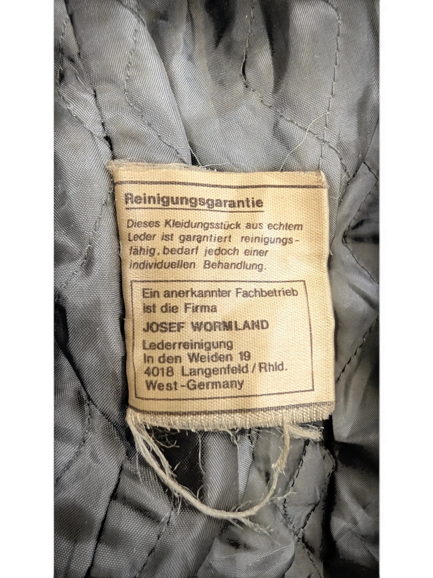 JAKE & IPI Josef Wormland leather jacket lining with care tag detailing leather cleaning instructions.