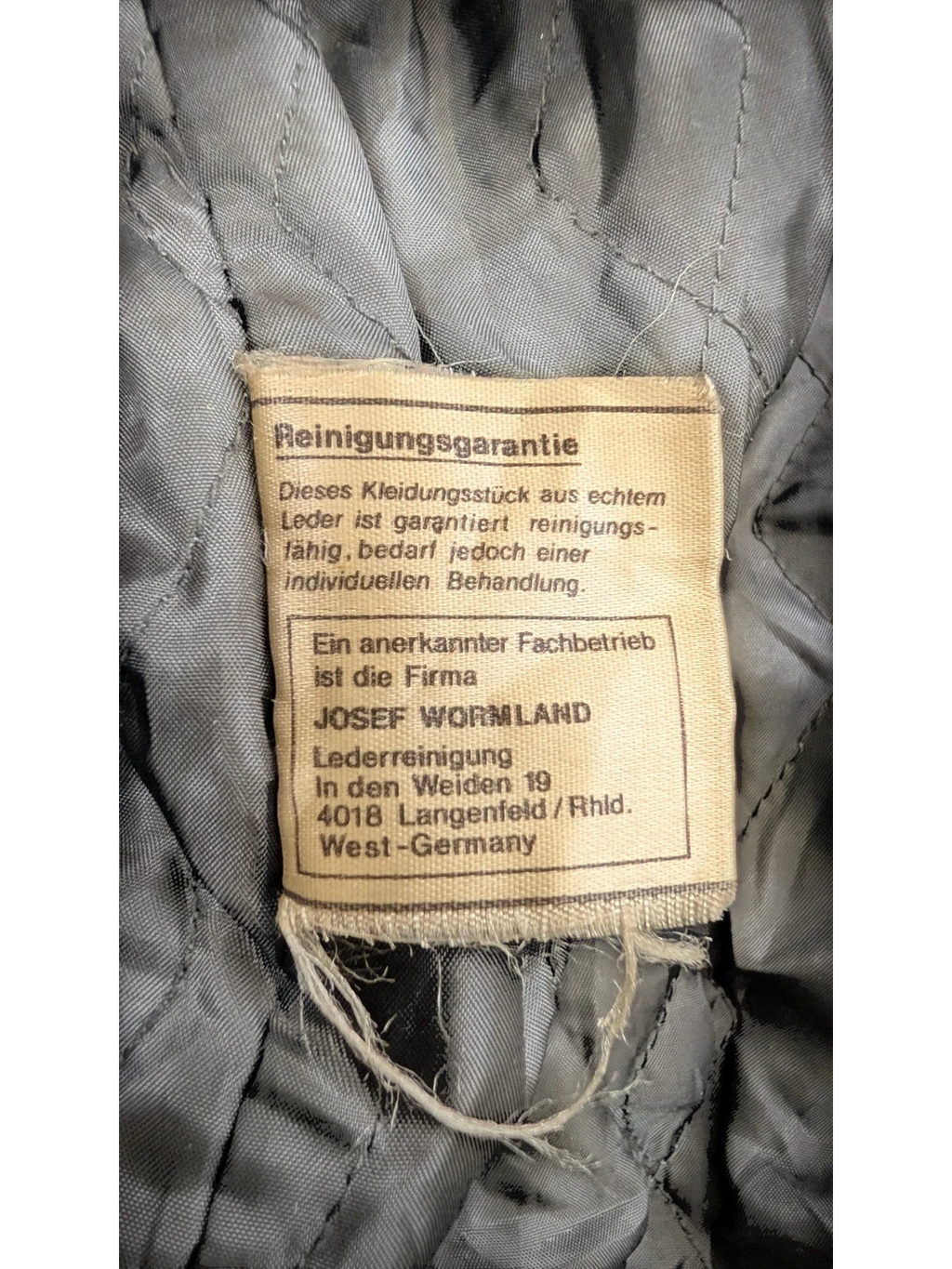 JAKE & IPI Josef Wormland leather jacket lining with care tag detailing leather cleaning instructions.