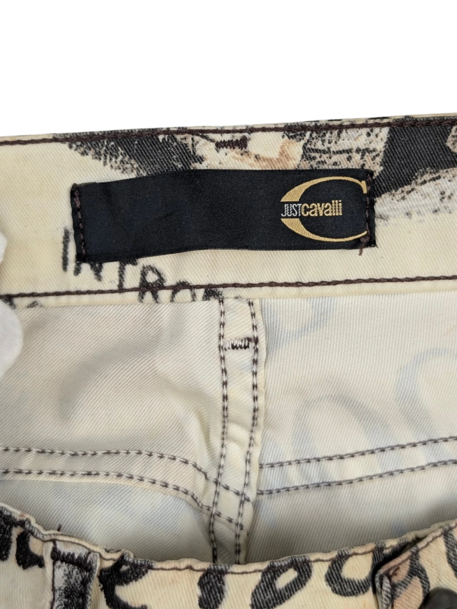 JAKE & IPI Just Cavalli newspaper print jeans in sepia, cream, and black. Slim fit, mid-rise, 5-pocket design.