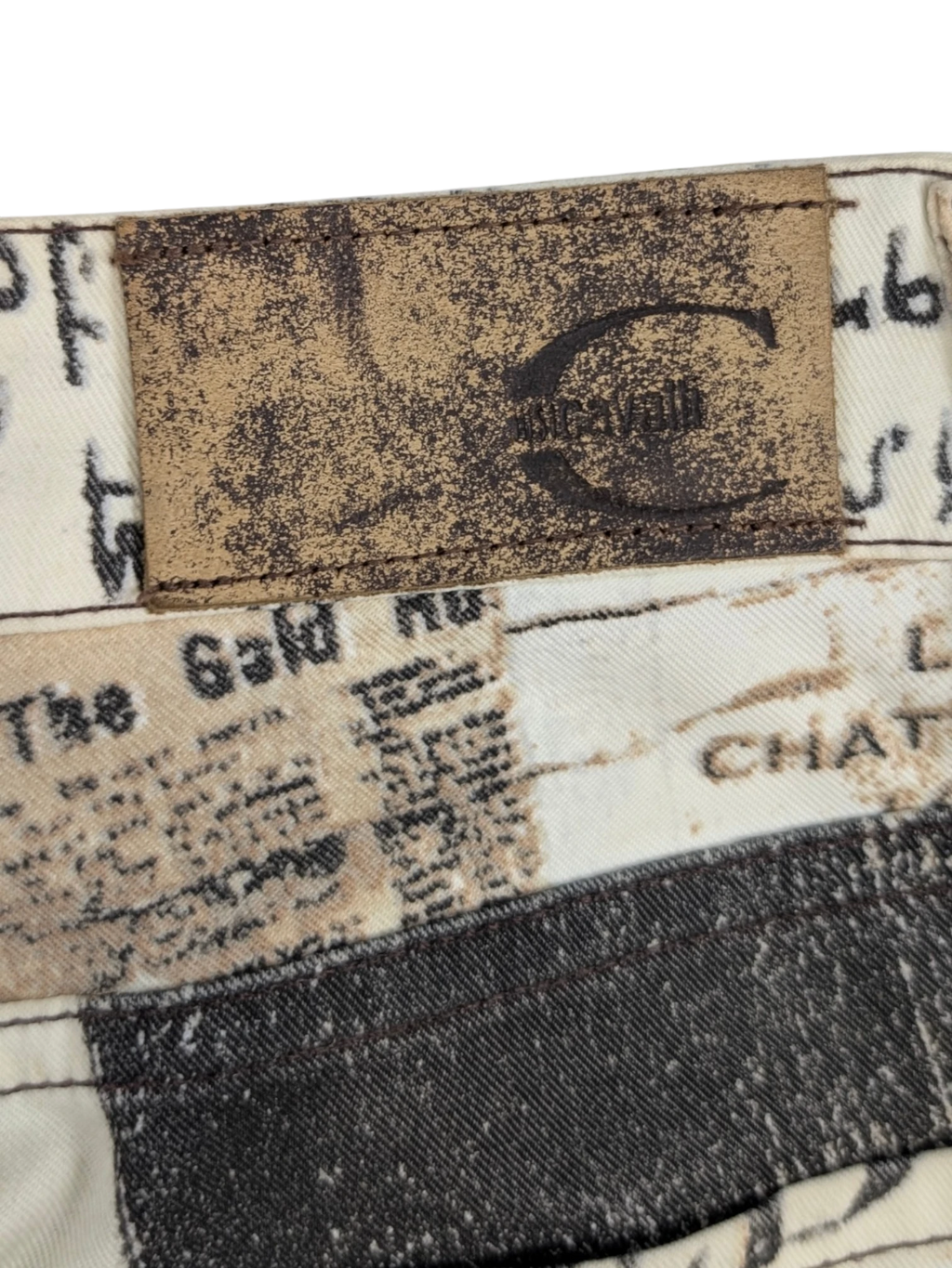 JAKE & IPI Just Cavalli newspaper print jeans in sepia, cream, and black. Slim fit, mid-rise waist, 5-pocket design. Y2K era.