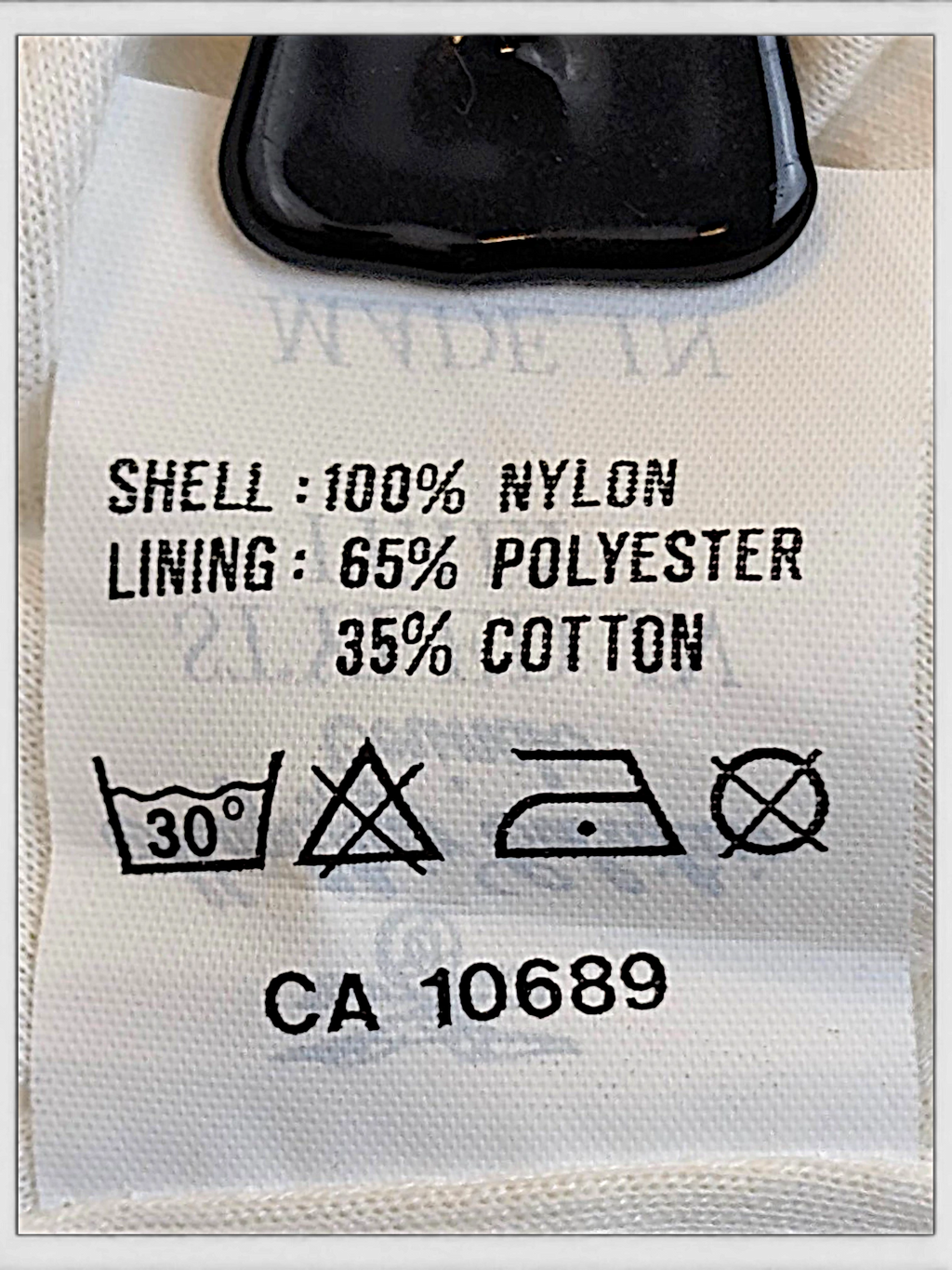 JAKE & IPI Kappa track pants care label showing 100 percent nylon shell and polyester cotton lining composition