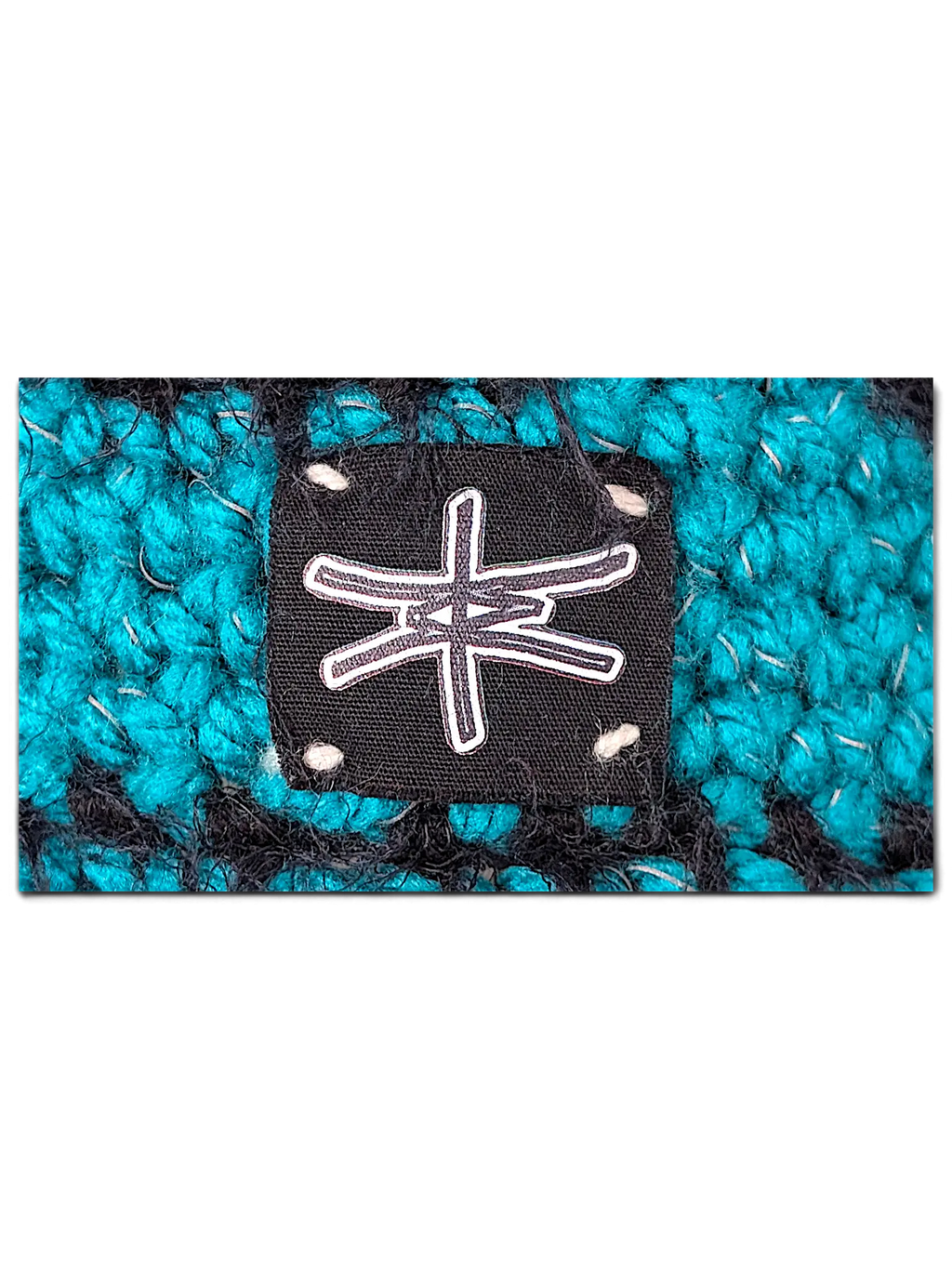 JAKE & IPI IBE knitted bucket hat featuring a black fabric logo patch with white stitching on a teal and black knit