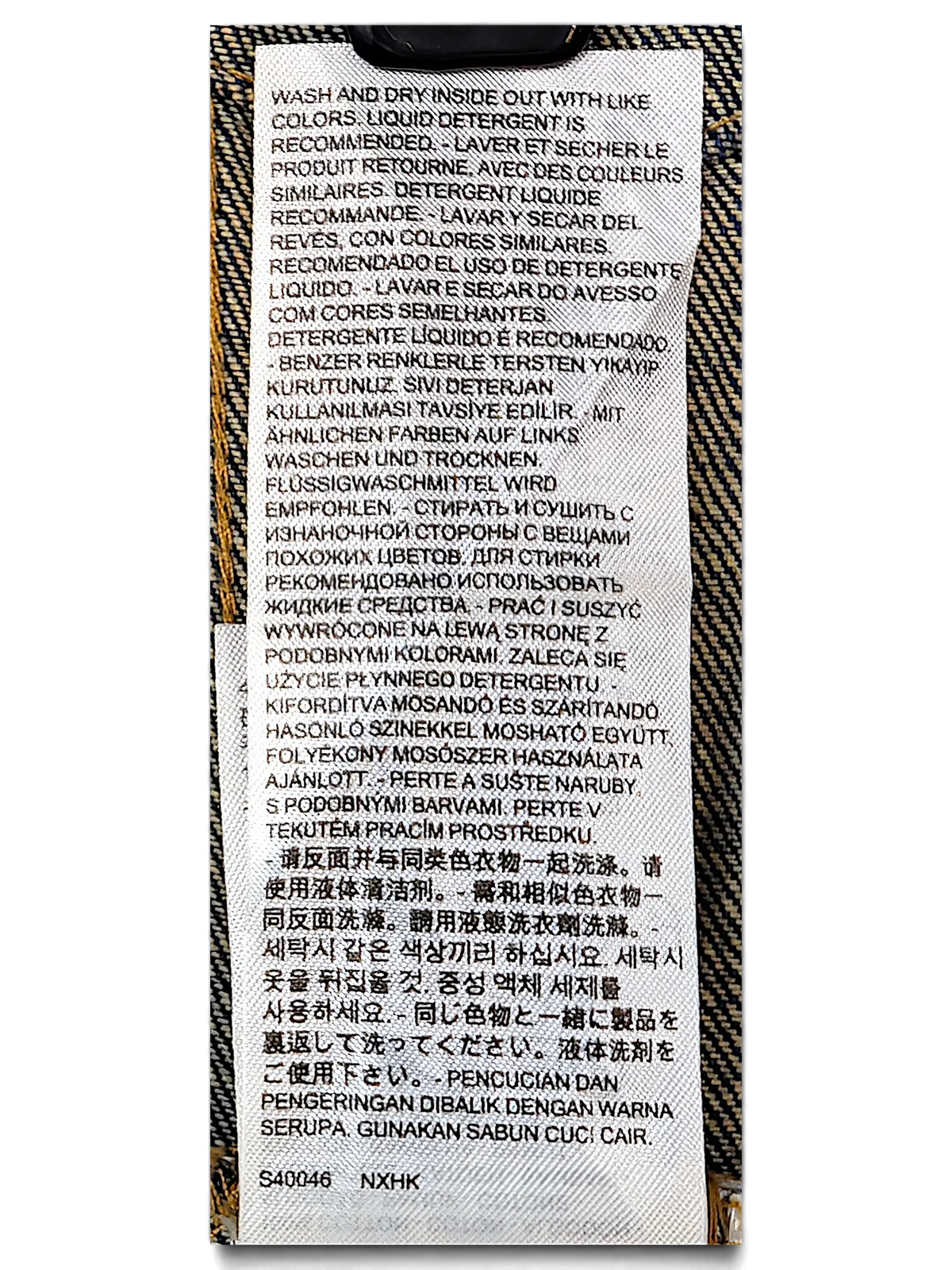 JAKE & IPI Levi's denim vest care instruction label with multi-language washing guidelines on white fabric