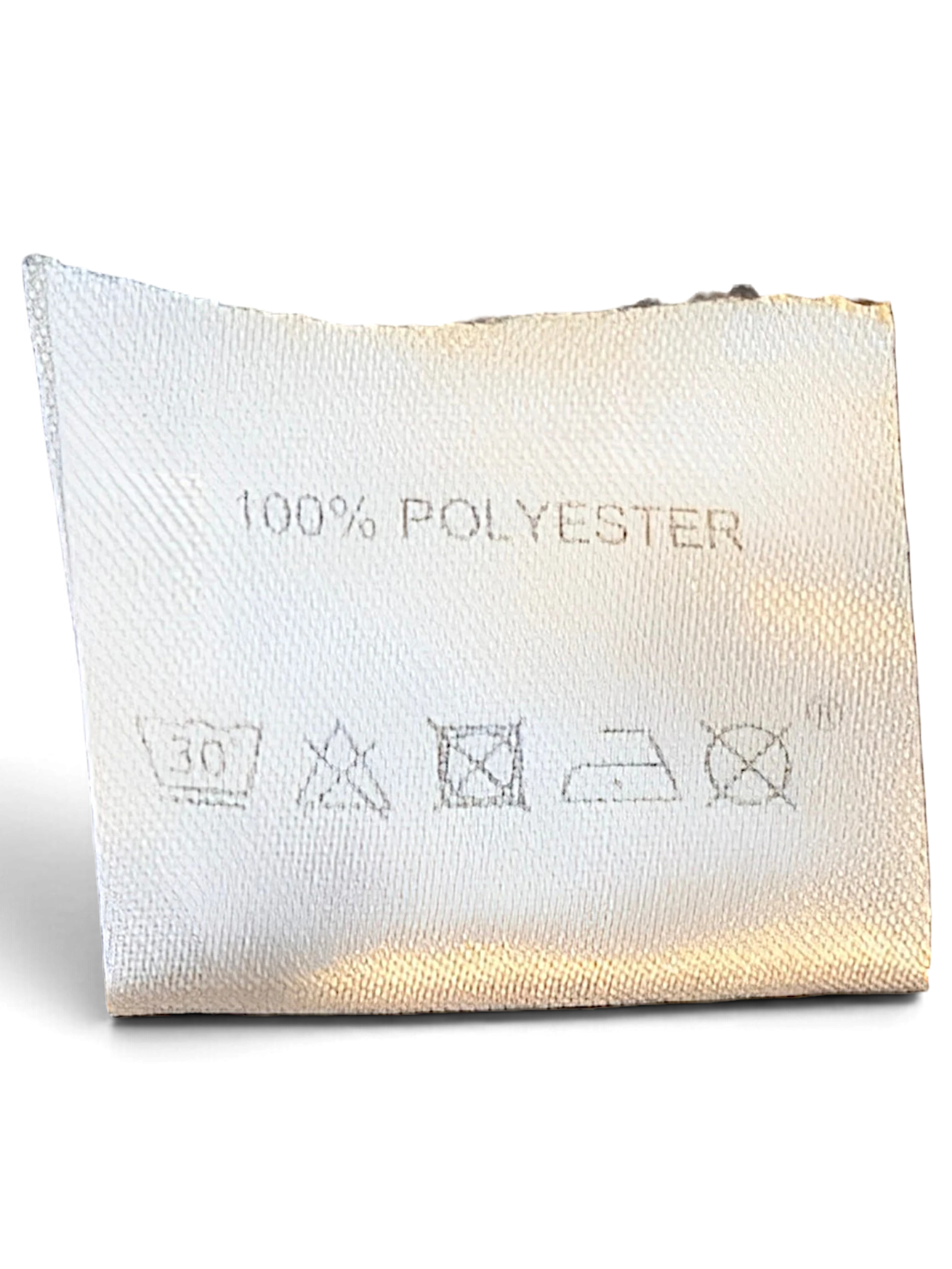 JAKE & IPI Lotto track pants care label showing 100% polyester composition and laundry instructions