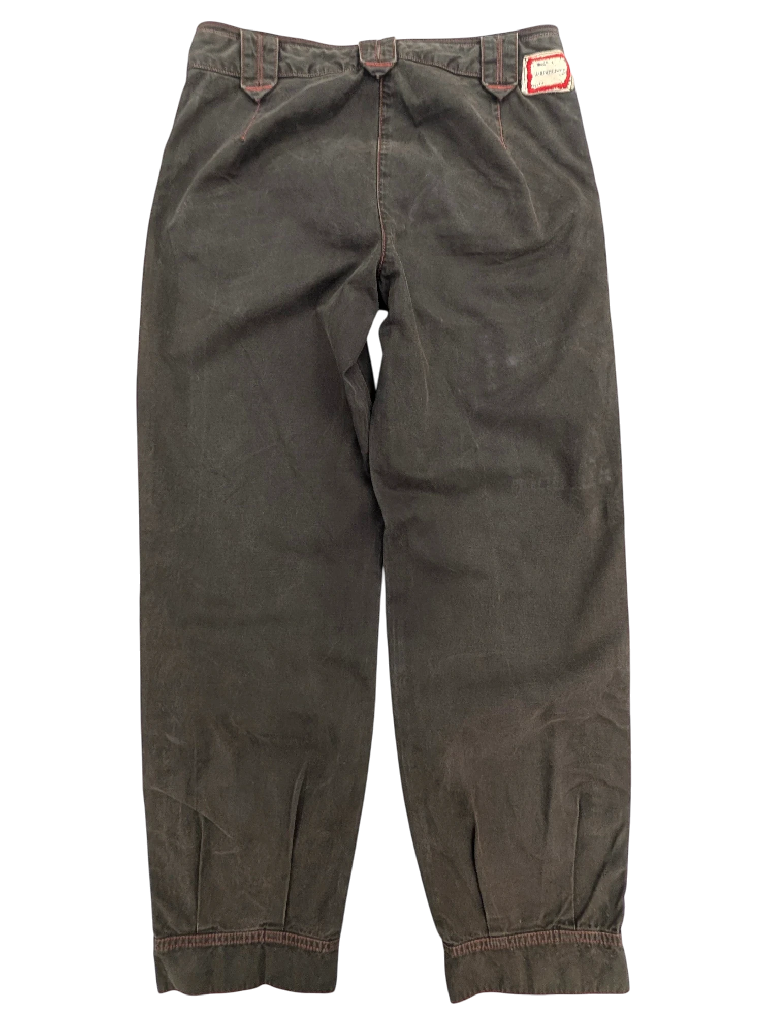 JAKE & IPI Murphy and Nye cargo pants in dark olive green cotton with red stitching detail and adjustable waist tabs.