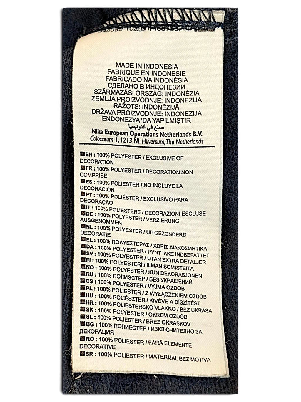 JAKE & IPI Nike track pants care label showing 100% polyester composition and manufacturing details in Indonesia.