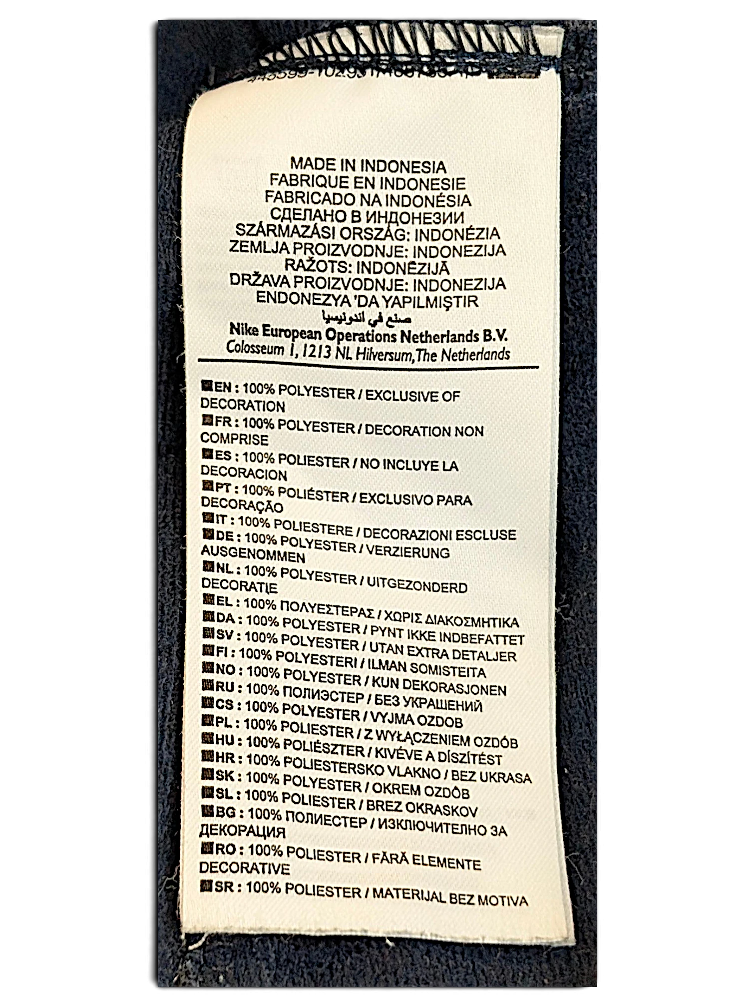JAKE & IPI Nike track pants care label showing 100% polyester composition and manufacturing details in Indonesia.