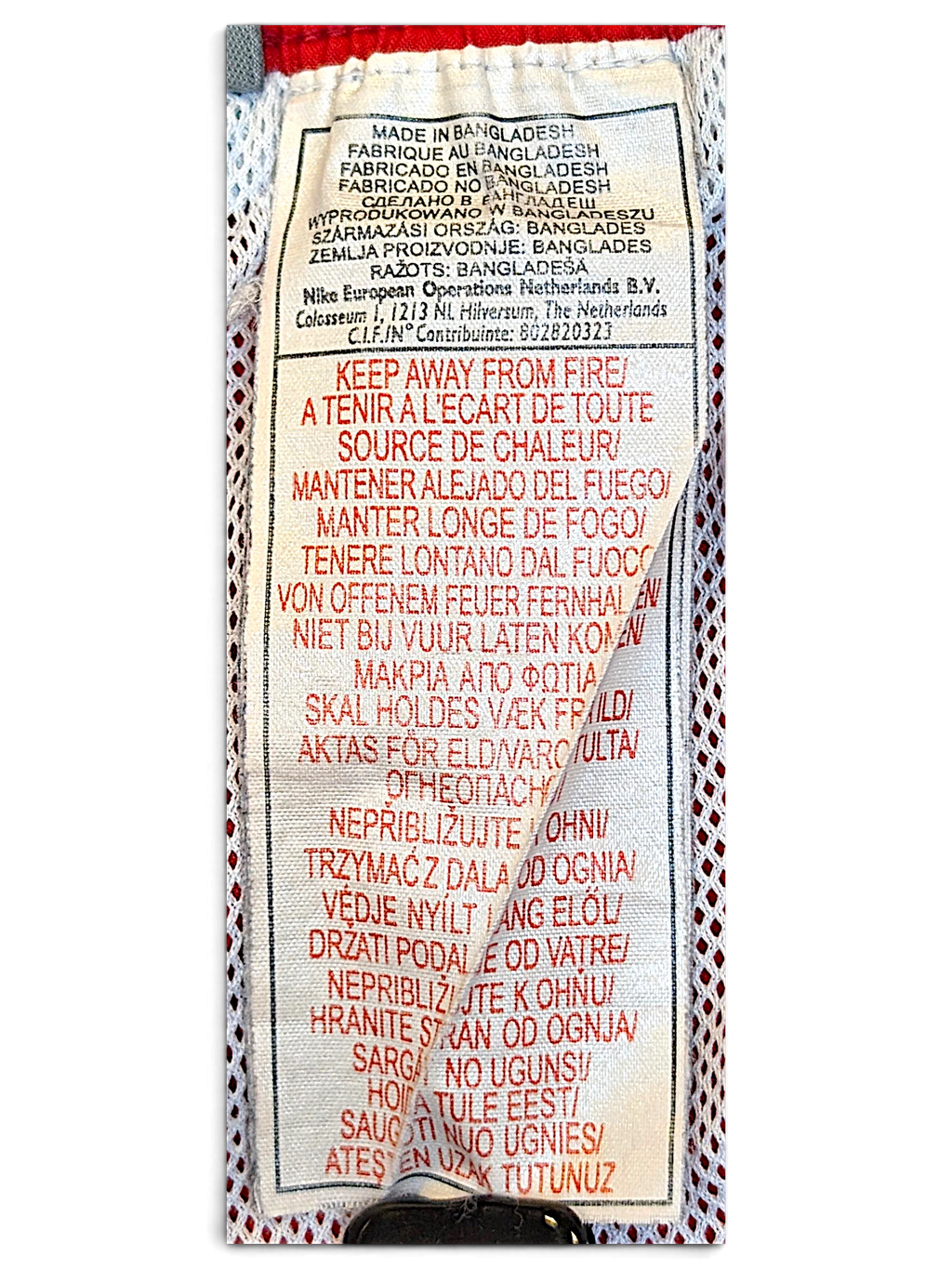 JAKE & IPI Nike track pants care and origin label showing manufacturing details in multiple languages