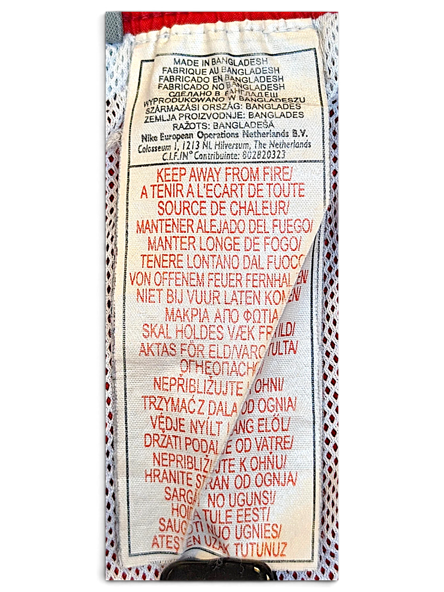 JAKE & IPI Nike track pants care and origin label showing manufacturing details in multiple languages