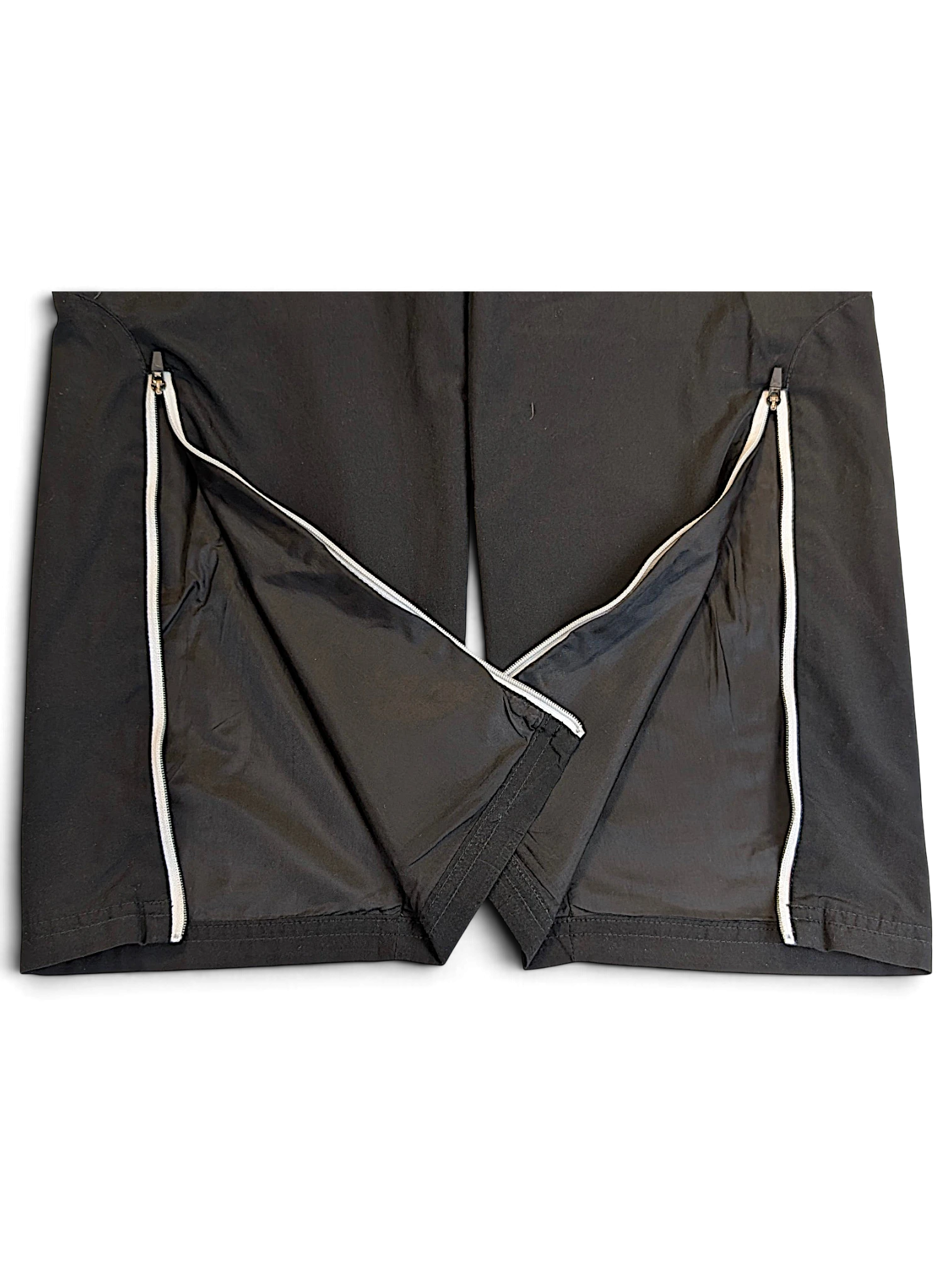 JAKE & IPI pre-owned Puma black track pants featuring white piping and functional zip hems at the leg openings.