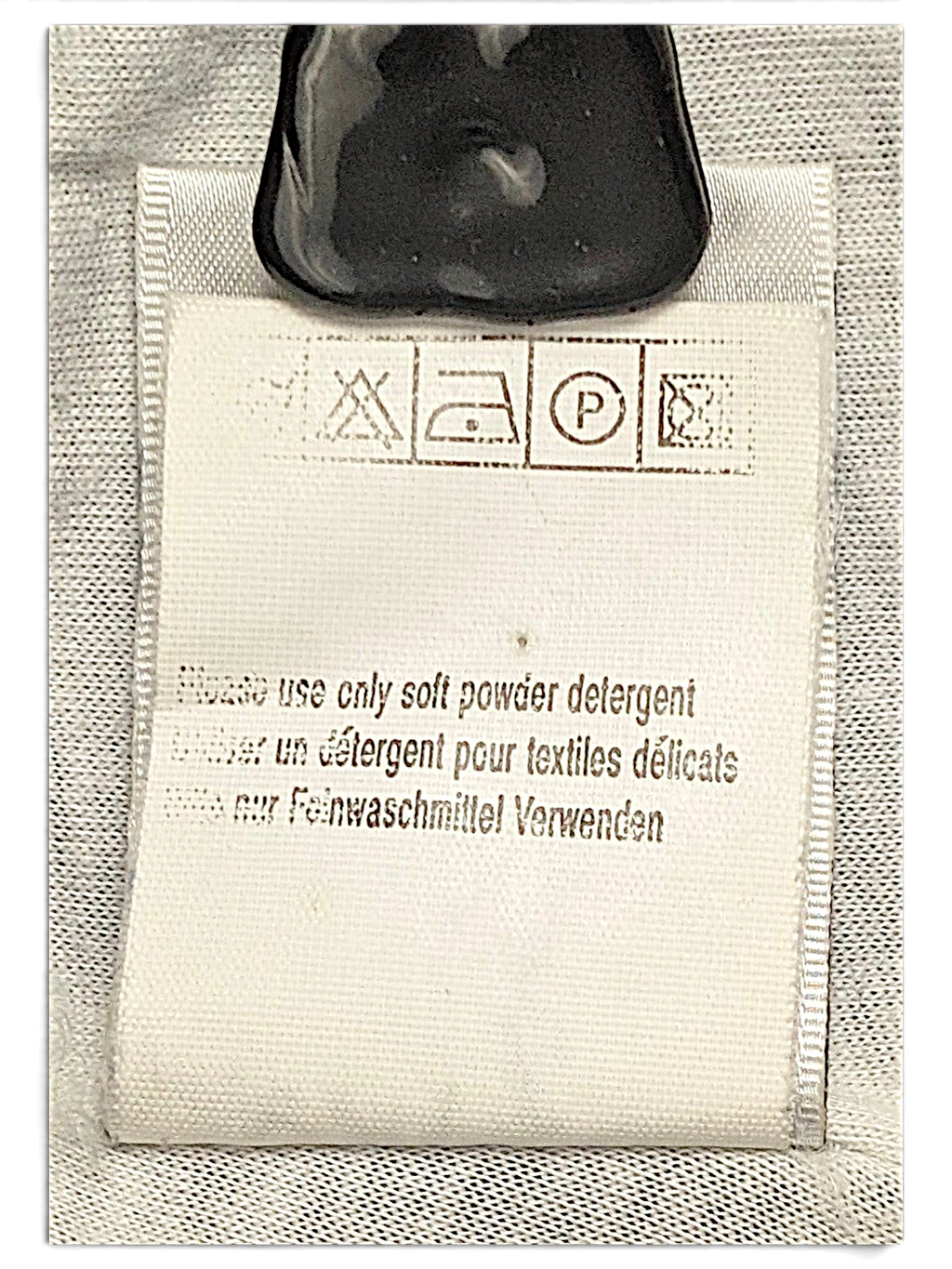 JAKE & IPI Puma track pants care label with washing instructions and symbols in English, French, and German.