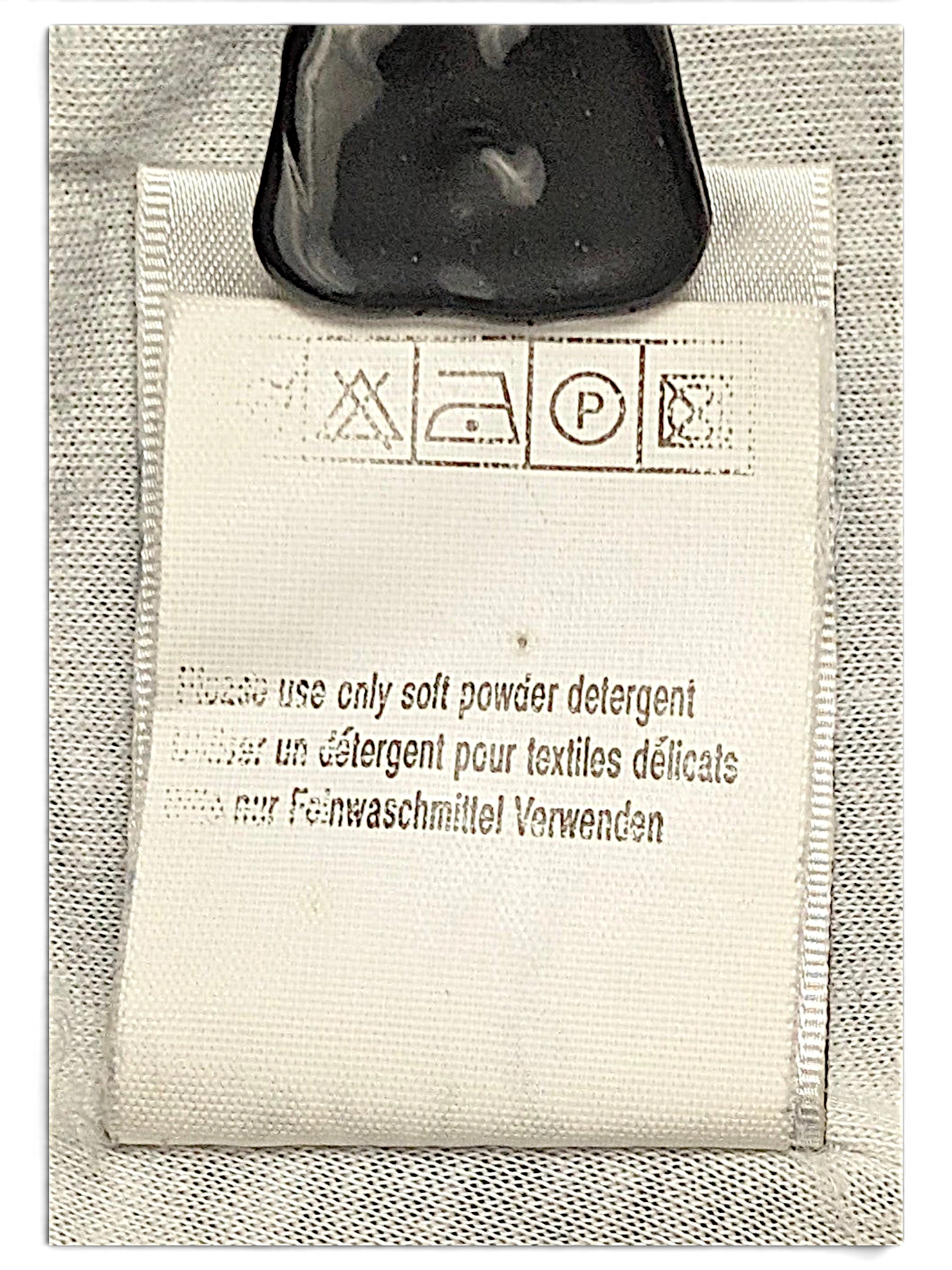 JAKE & IPI Puma track pants care label with washing instructions and symbols in English, French, and German.