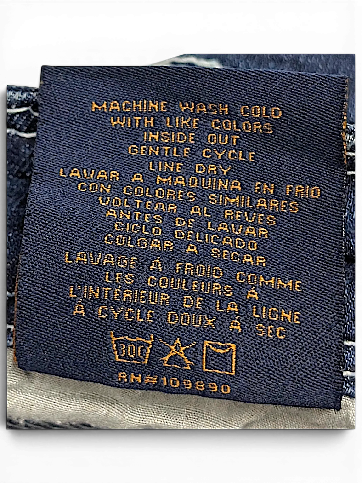 JAKE & IPI Seven7 capri jeans care label with washing instructions in English, Spanish, and French.