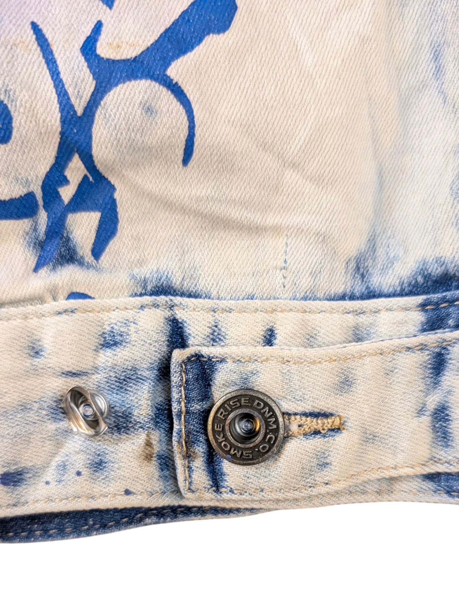 JAKE & IPI Smoke Rise denim jacket with blue graphic print and distressed wash. Features metal button closure.