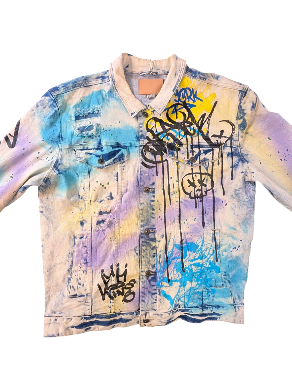 JAKE & IPI Smoke Rise denim jacket with graffiti print, distressed details, and tie-dye effect in blue, yellow, and purple.