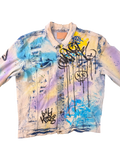 JAKE & IPI Smoke Rise denim jacket with graffiti print, distressed details, and tie-dye effect in blue, yellow, and purple.