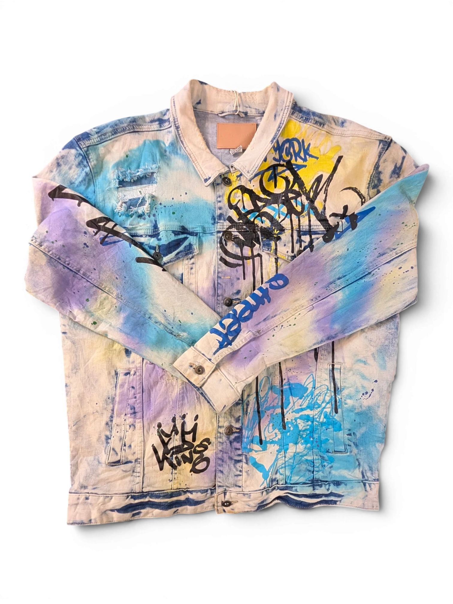 JAKE & IPI Smoke Rise denim jacket with tie-dye effect, graffiti print, distressed details, and a classic collar.