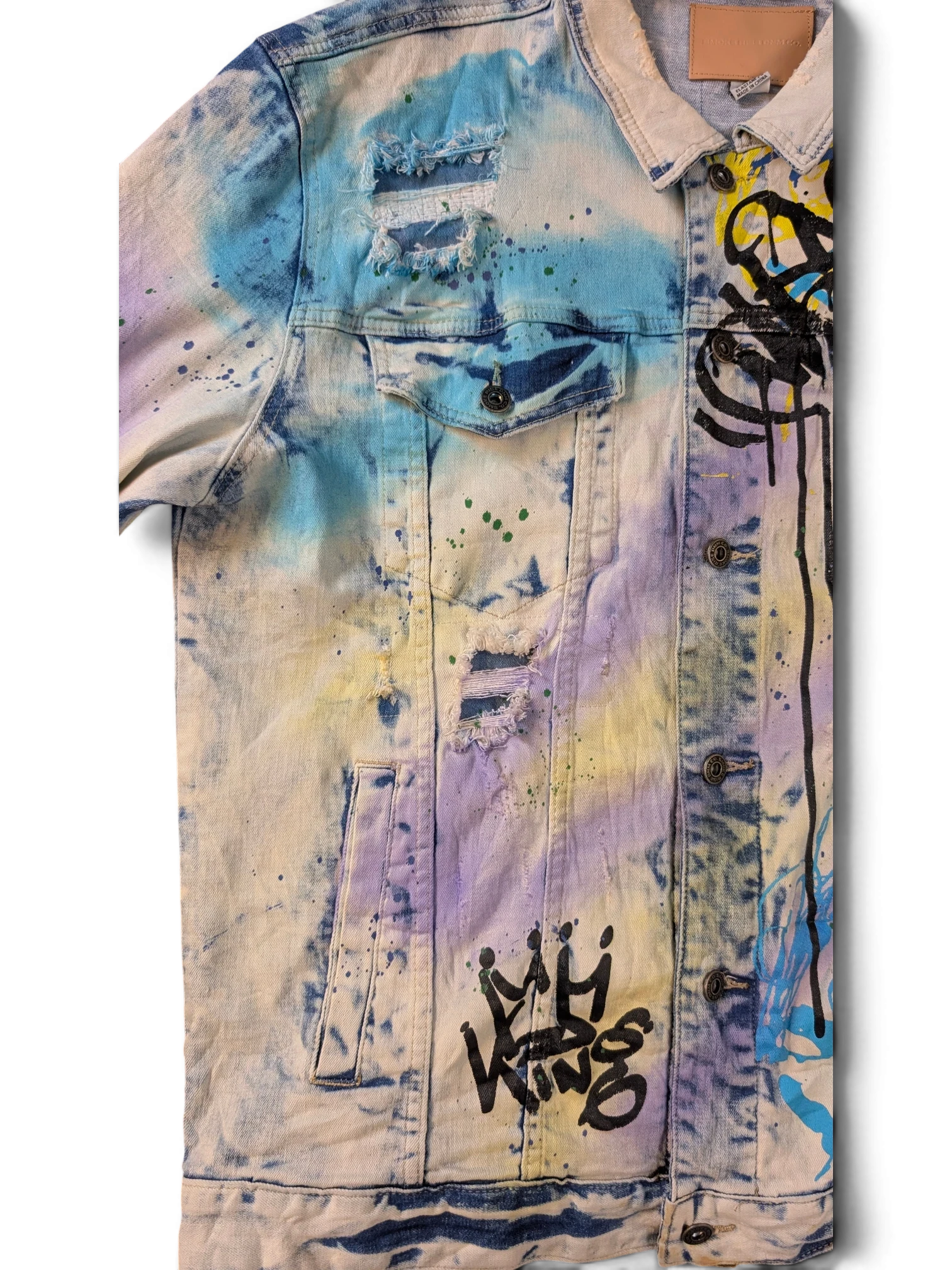JAKE & IPI Smoke Rise denim jacket with tie-dye wash, distressed details, and graffiti art.