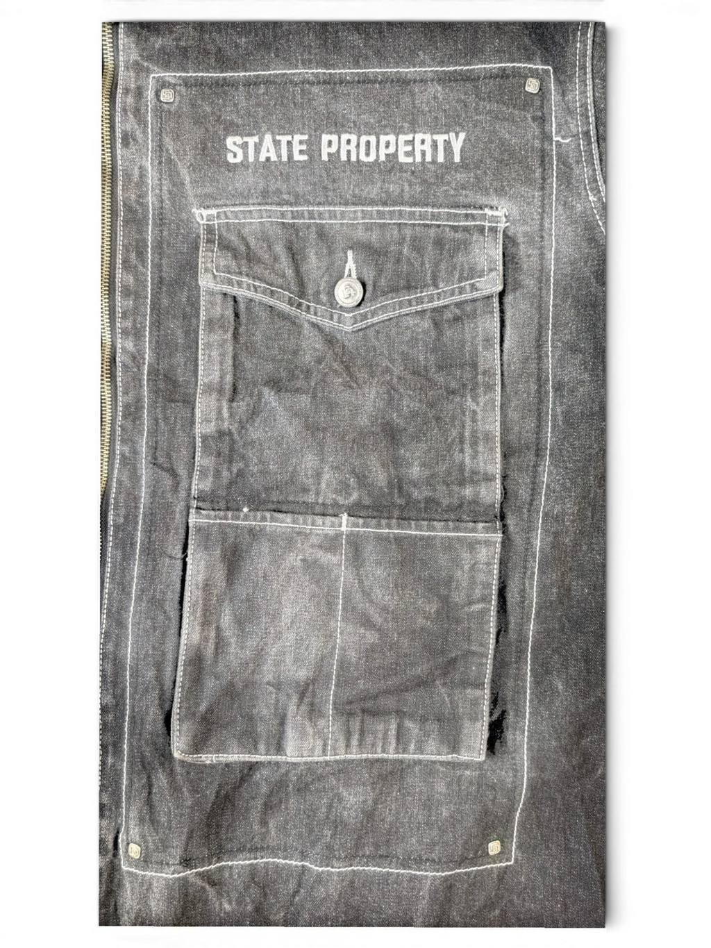 JAKE & IPI State Property dark grey denim jacket with white contrast stitching and button-flap chest pocket.