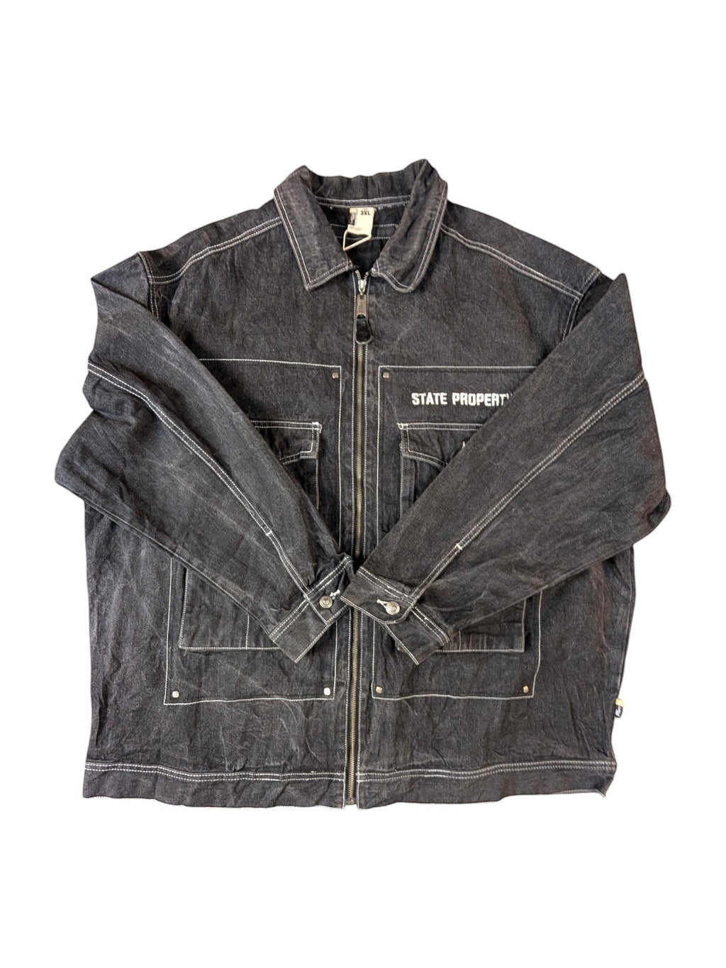 JAKE & IPI State Property dark wash denim jacket with white contrast stitching, zip-up front, and multiple pockets.