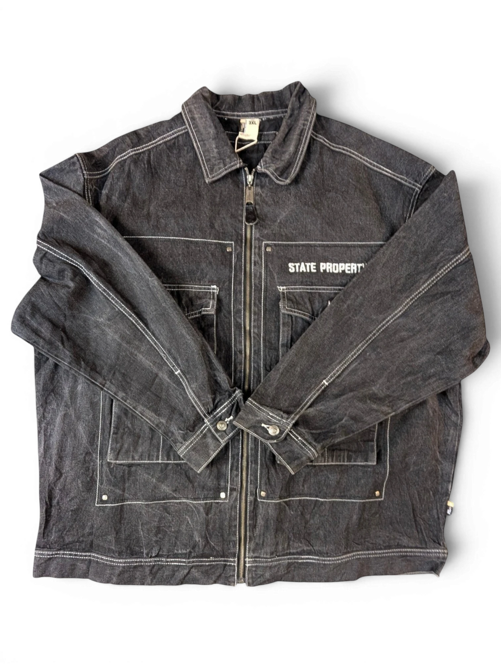 JAKE & IPI State Property dark wash denim jacket with white contrast stitching, zip-up front, and multiple pockets.