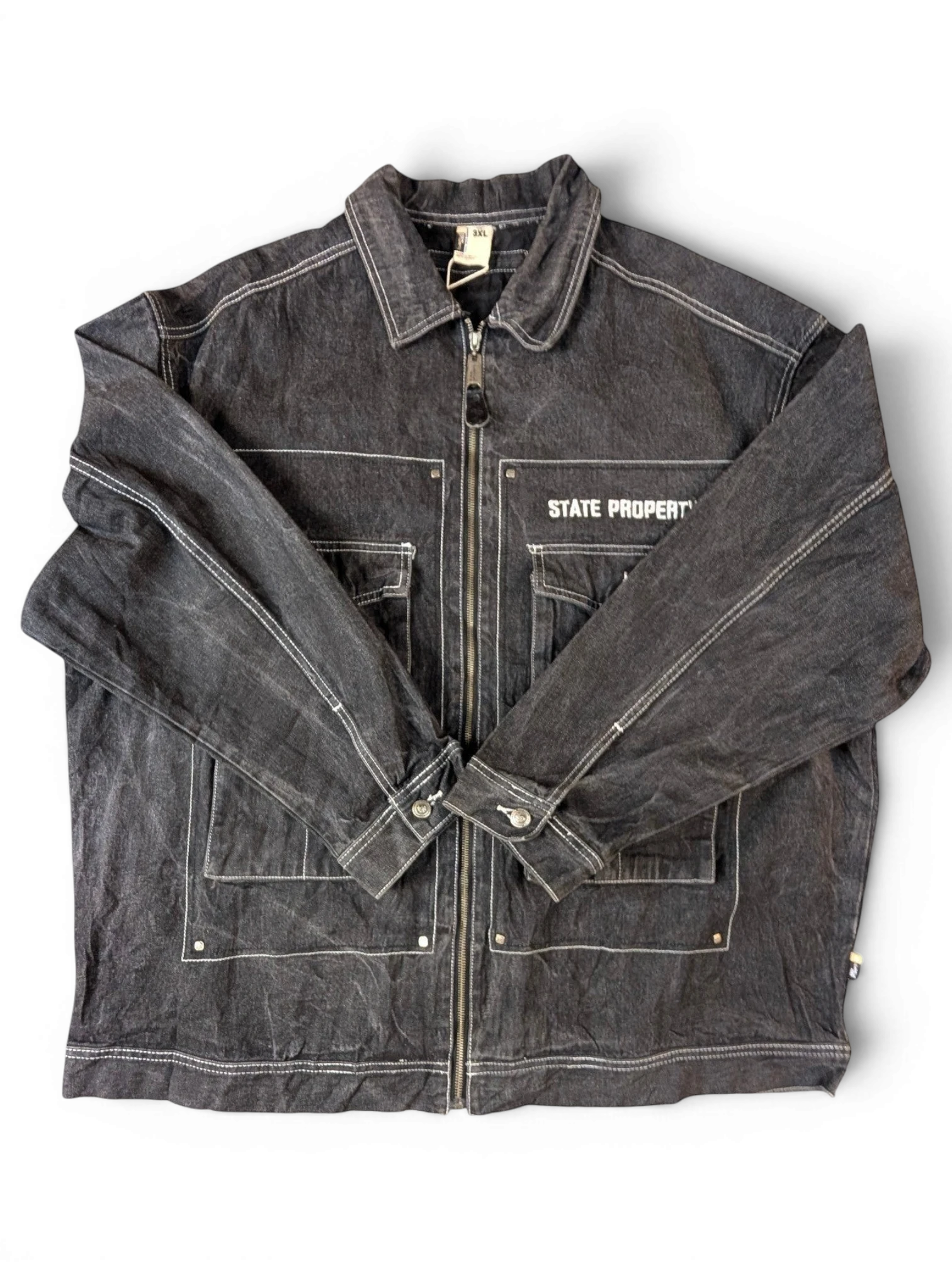 JAKE & IPI State Property dark wash denim jacket with white contrast stitching, zip-up front, and multiple pockets.