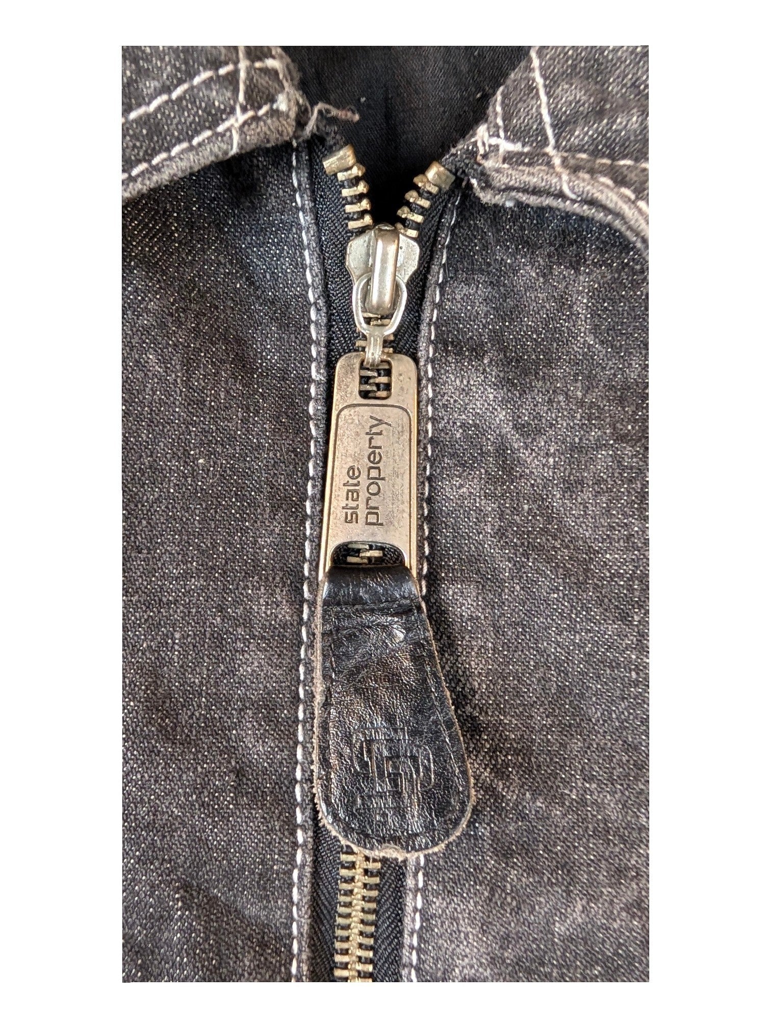 JAKE & IPI State Property dark wash denim jacket with silver zipper and white stitching.